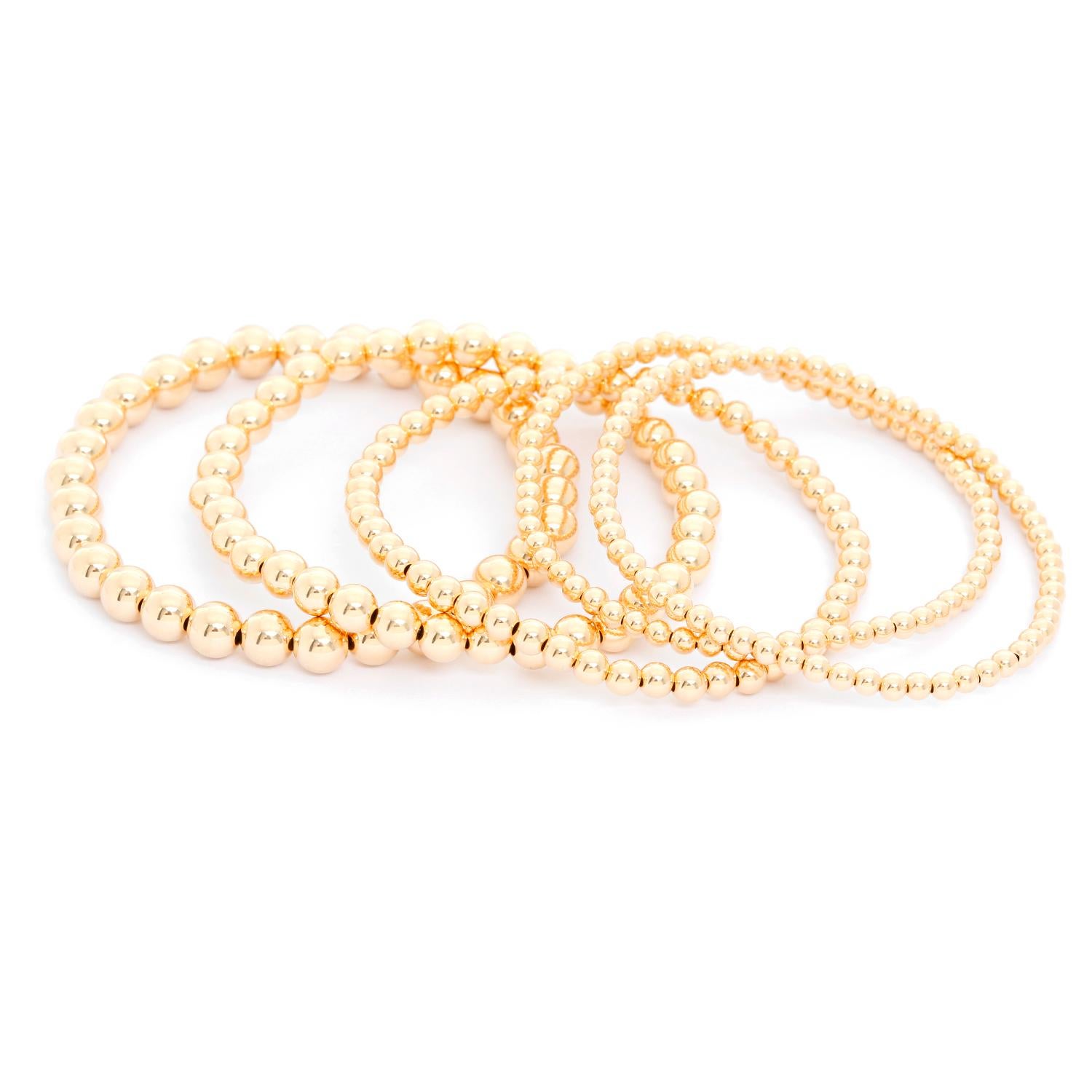 Gold Bead Ball Stretch Bracelets - Five stack-able bead bracelet. Pictured  two 3 mm, one 4 mm, one 5mm, one 6mm.  New with DeMesy pouch. Wearable all day and in the shower and they will still hold their luster and stretch.