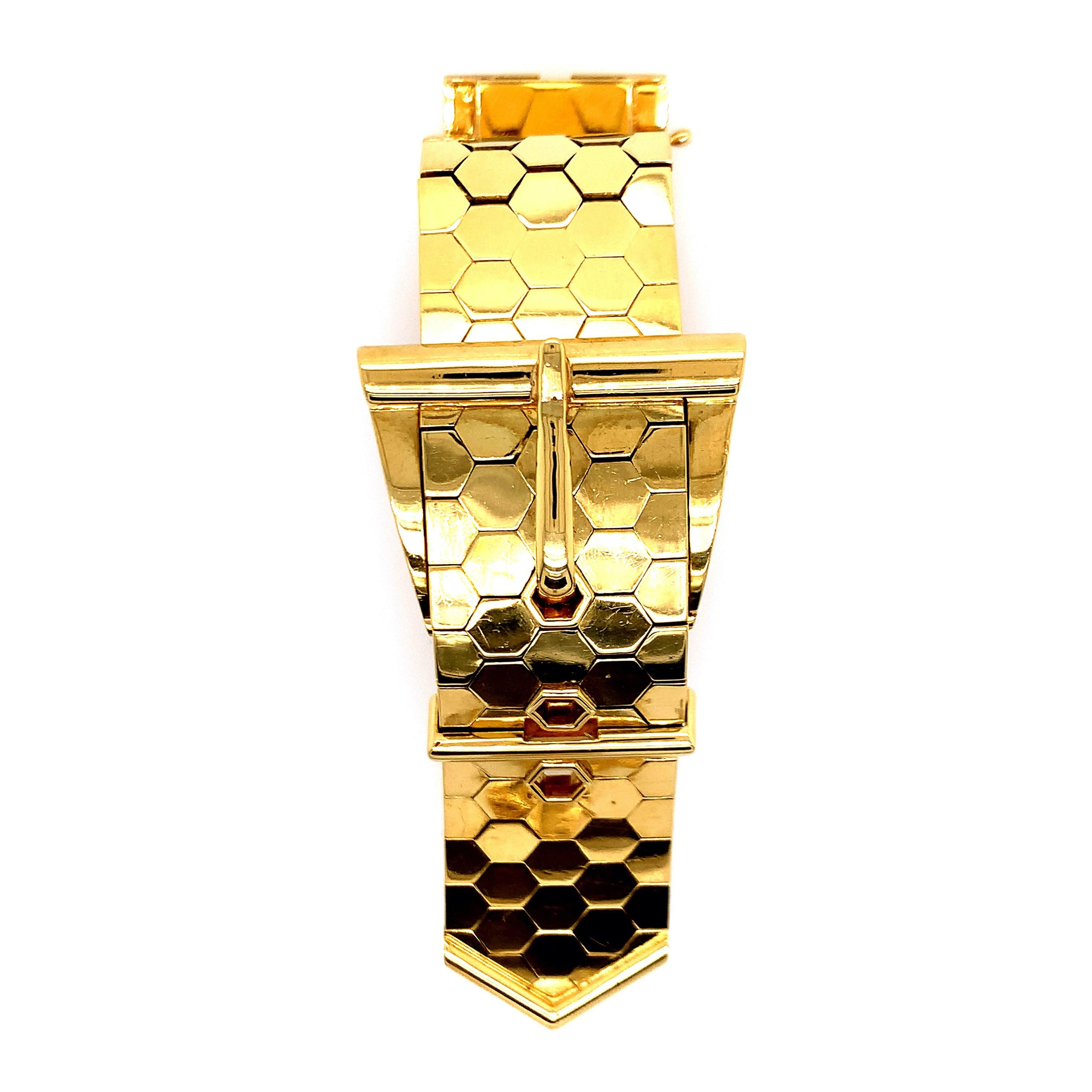 An 18 karat yellow gold wrist watch, with a belt buckle design. The strap has a honey comb pattern, allowing it to be flexible. The movement is International Watch Company (IWC). Made in Switzerland. Maker's mark: HP. Serial No. 1362265. Inner