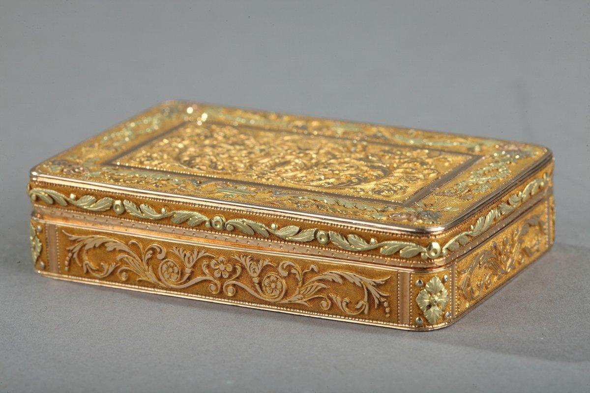 Exceptional rectangular box or snuff box in four-tone gold. The hinged lid in fine relief has an astonishing composition: the central panel in Amati gold is decorated with symmetrical motifs of foliage and flowers. This panel is framed by a frieze