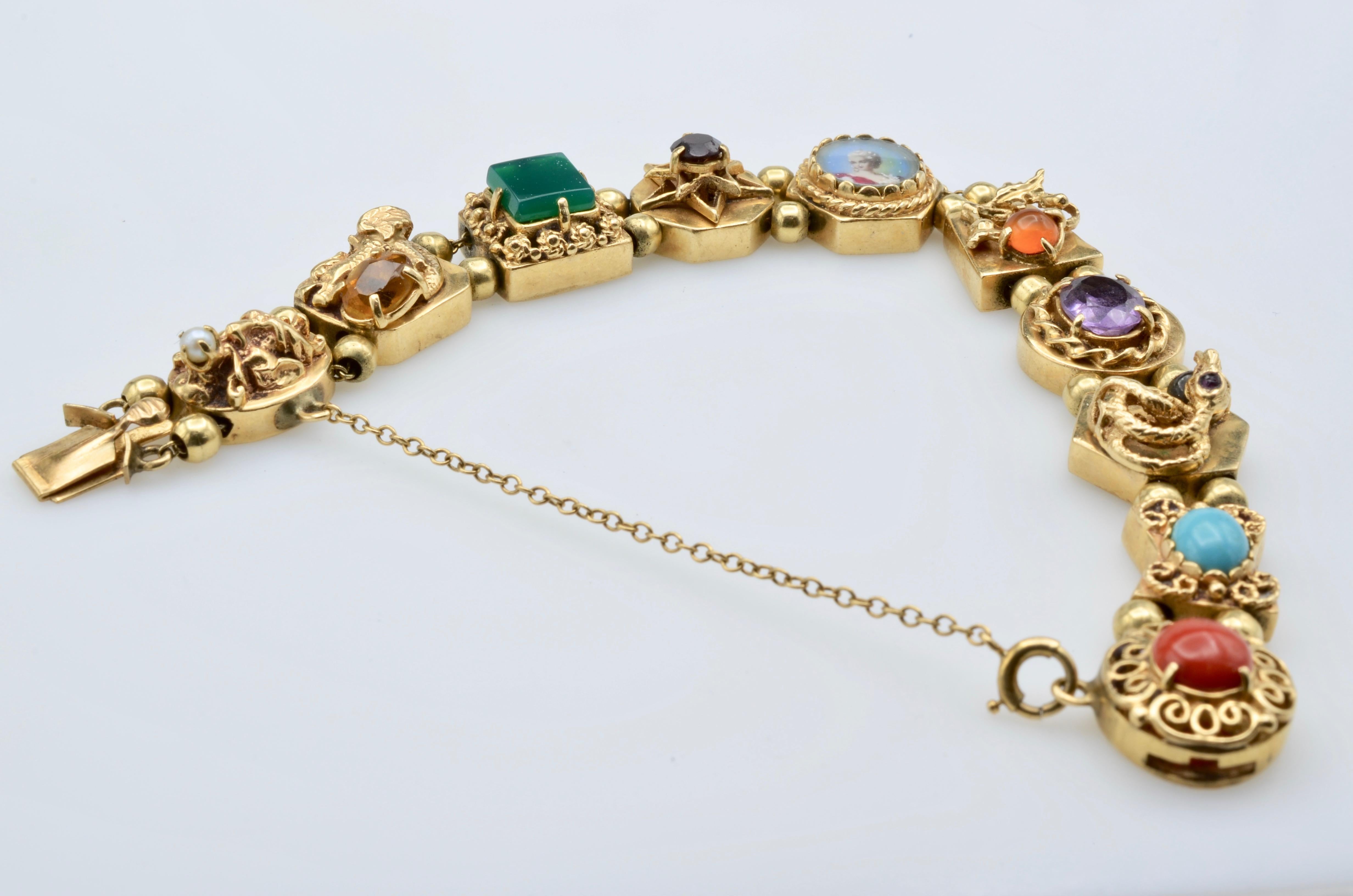 This stunning slider bracelet is a collection of semi precious stones set in unusual carvings of snake, a dragon and a menagerie of filigree carvings.They all slide on two tandem 14k gold chains. The clasp has a safety chain. You will not tire of