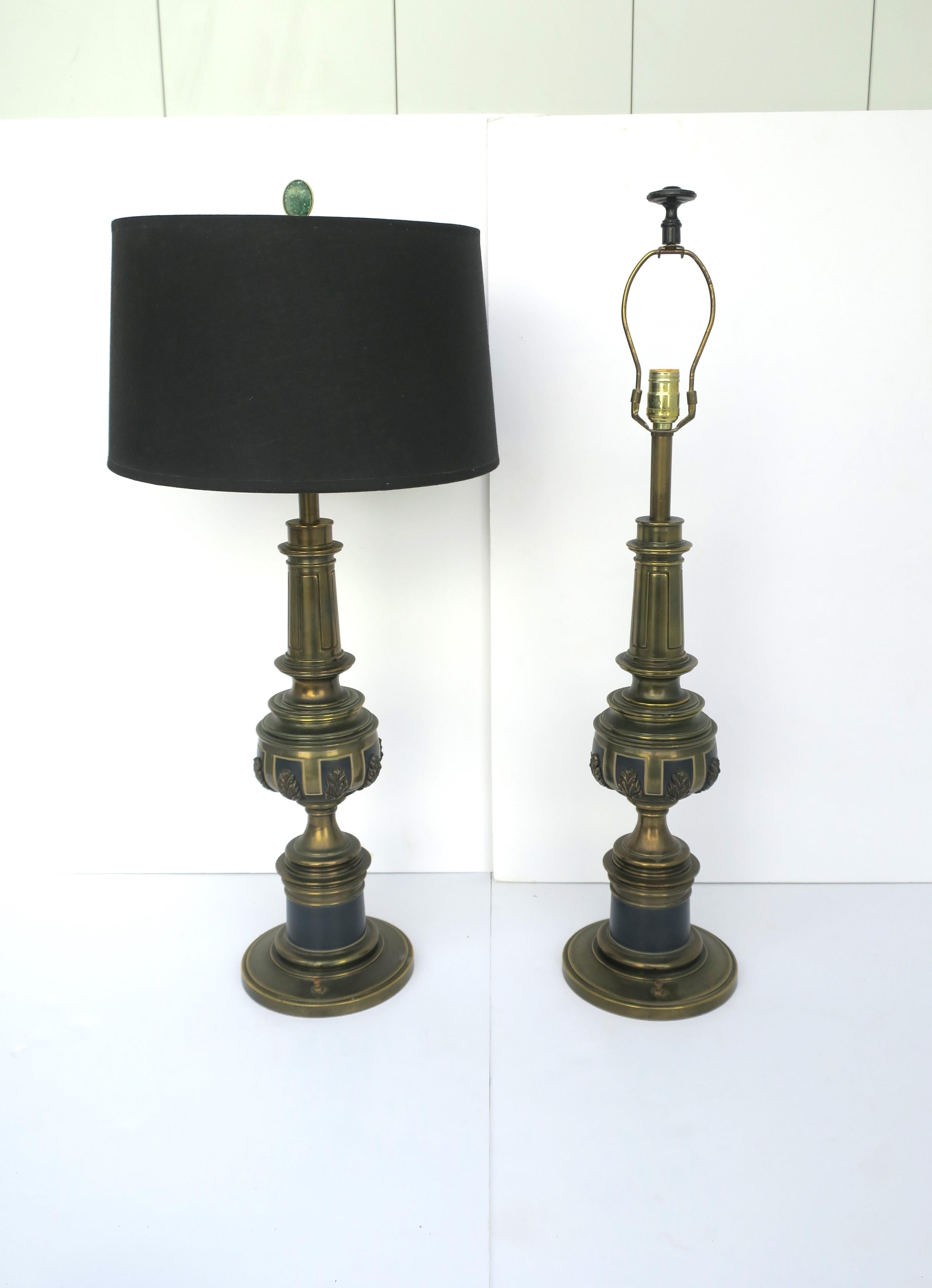 A substantial pair of tall brass table lamps with black matte enamel and leaf detailing by Stiffel, circa mid-20th century, 1960s. On/off switch conveniently located on front/center base area and at top socket. 

Each lamp measures: 
27.75