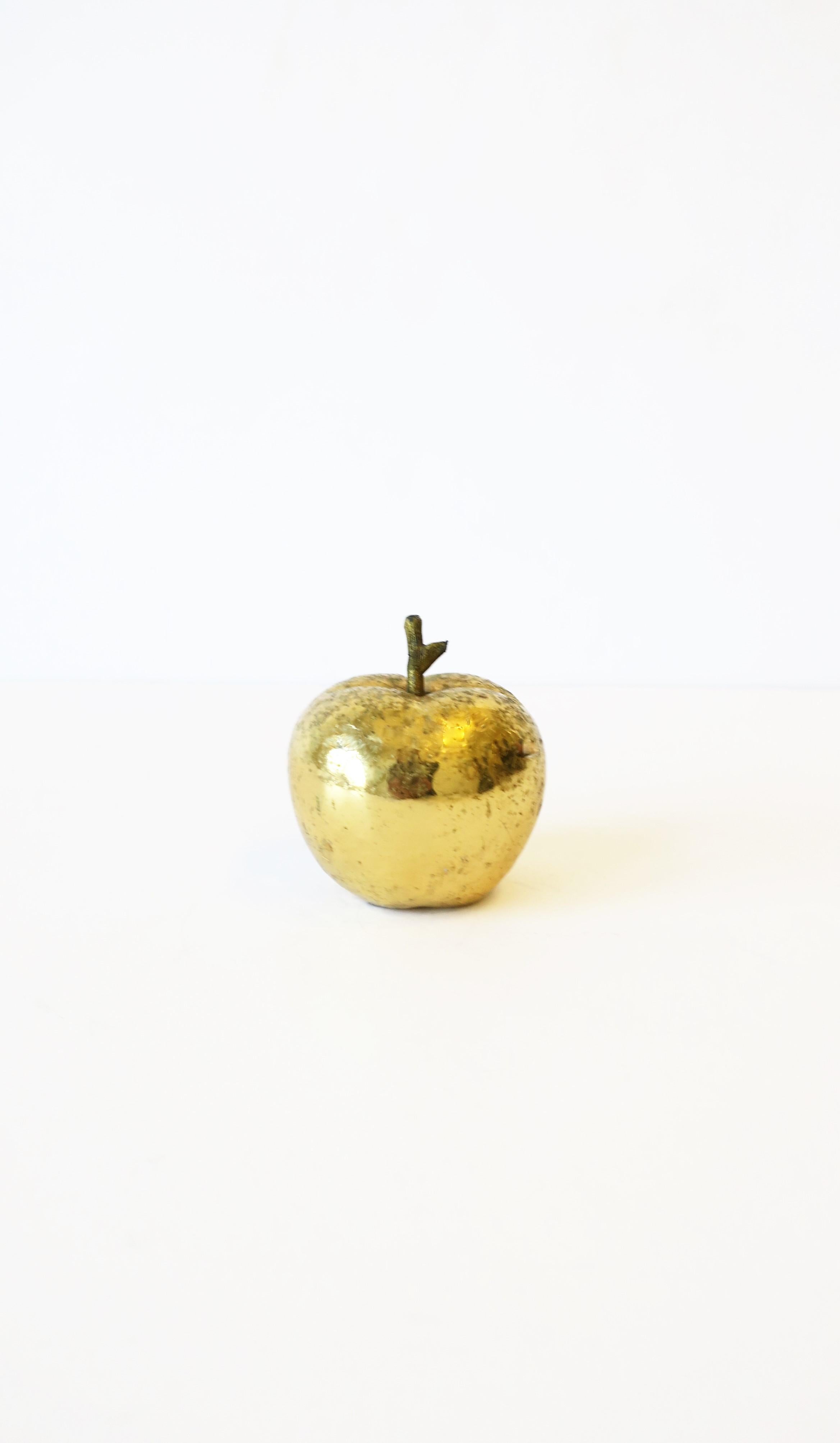 A substantial gold apple sculpture decorative object or paperweight. Apple has a bright and reflective gold exterior over bronze or brass with detailed stem. A cool piece for a desk or other area. Piece measures: 2