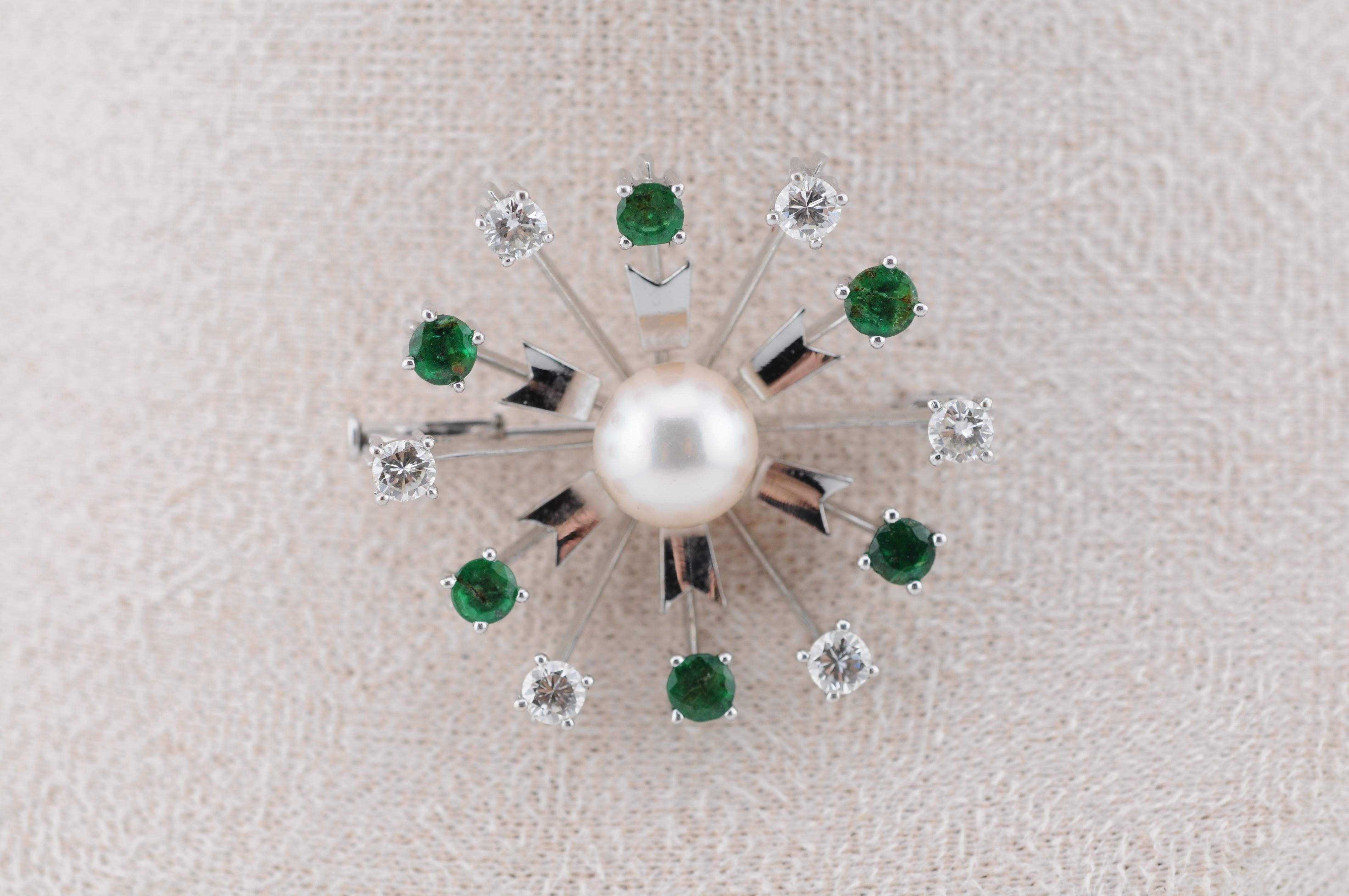 Raffinata spilla realizzata in oro bianco 14 carati:
- 6 smeraldi naturali (ciascuno di circa 0,10 carati)
- 6 diamanti taglio brillante (ciascuno di circa 0,10 carati - totale circa 0,60 carati)
- Una perla coltivata centrale in una graziosa