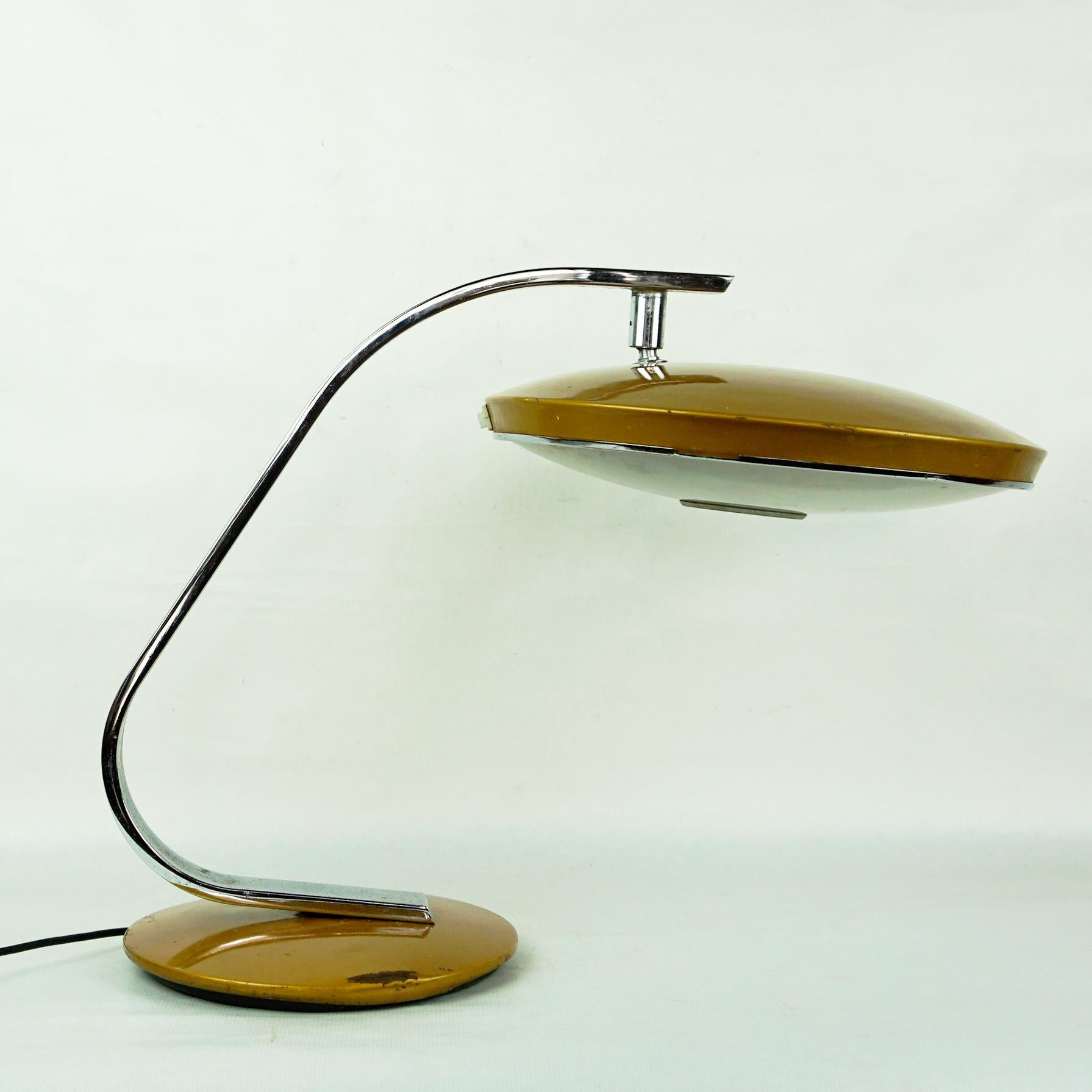 Drehbare, goldbraun emaillierte Metall-Tischleuchte des spanischen Leuchtenherstellers Fase Madrid entworfen  in den 1960er Jahren.
Sie verfügt über einen verstellbaren, scheibenförmigen Schirm mit Milchglasdiffusor, Kugelgelenk, mit 2 Fassungen für