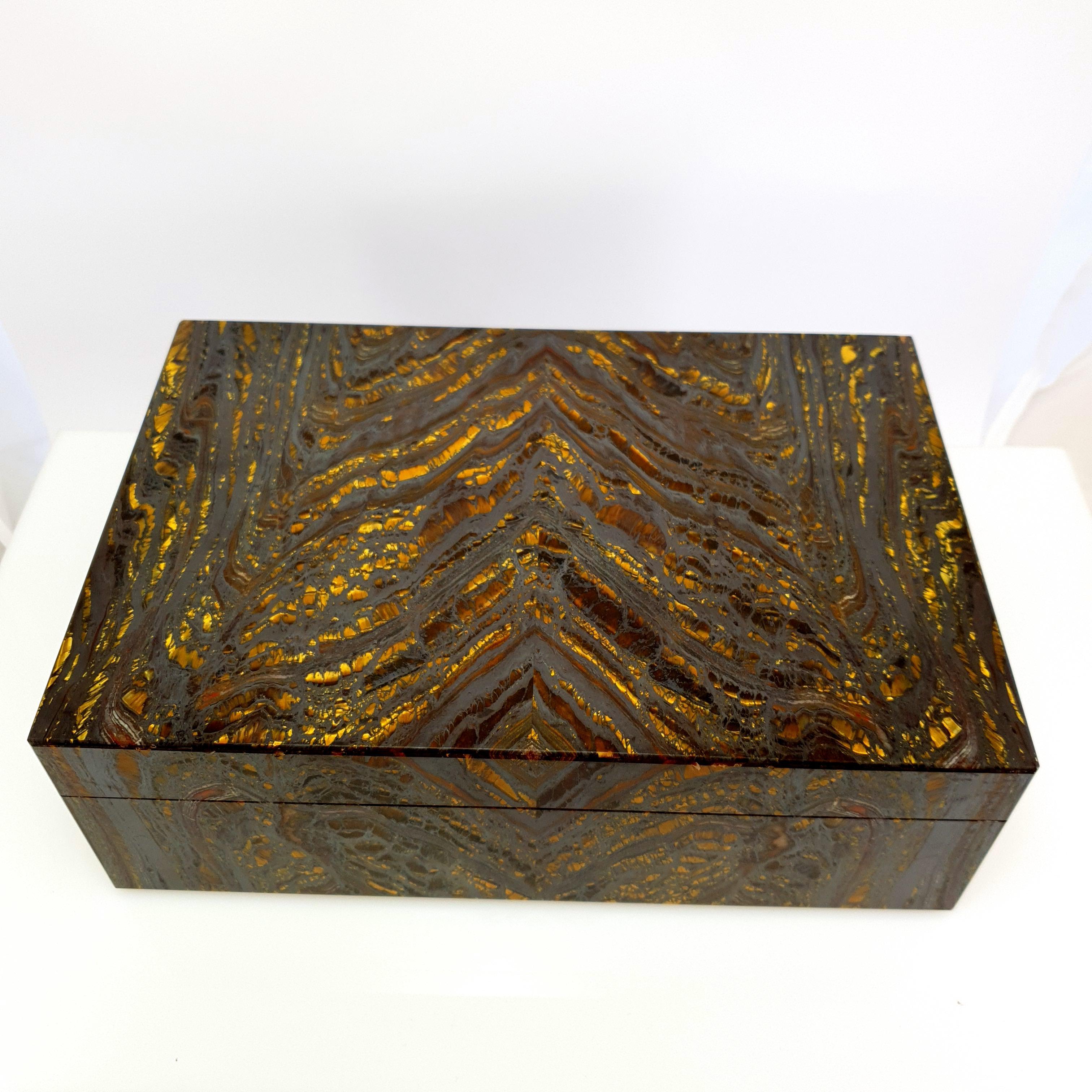 A Natural Handmade Gold brown Tiger Iron Decorative Jewelry Gemstone Box with black Marble Inlay.
The golden brown colour stripes and pattern looks like an artful painting of nature. 
It should be emphasized that the top and bottom plate is made