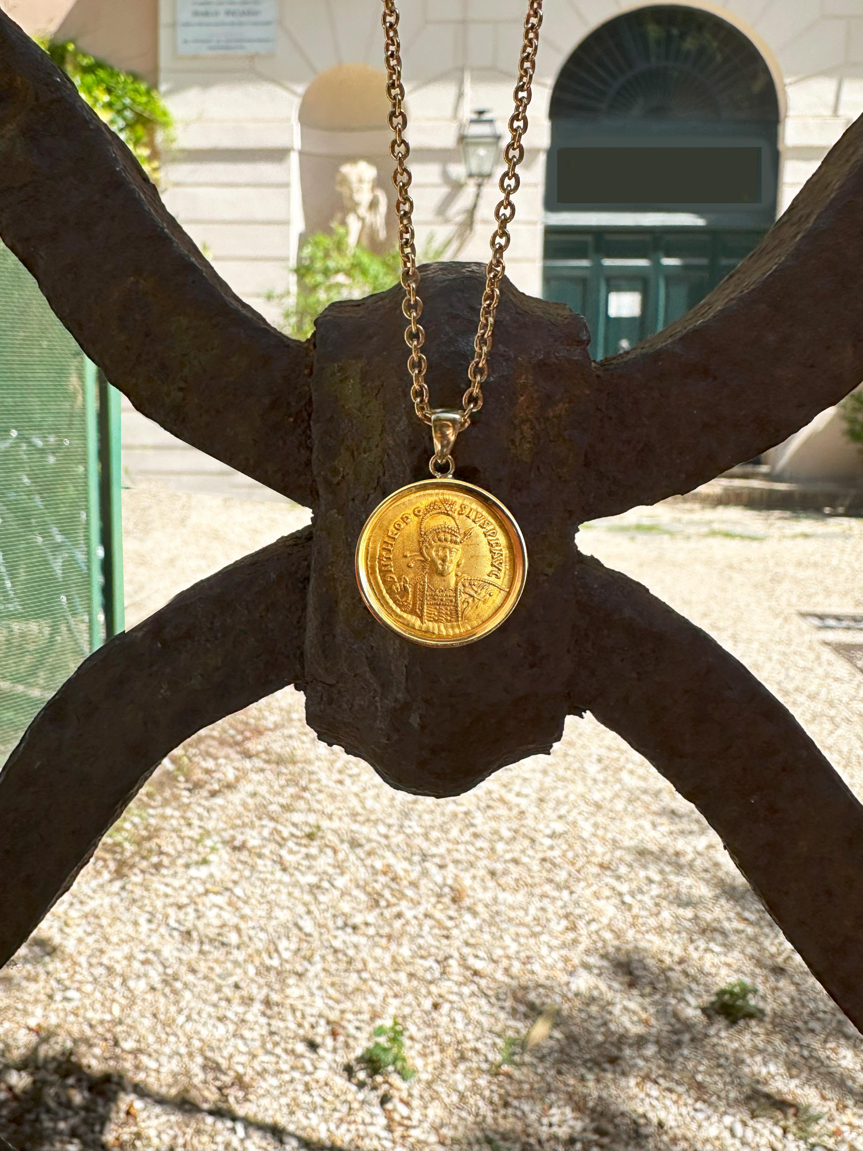 This magnificent 18 Kt gold pendant features an authentic Roman coin (solidus) in 24 Kt gold, dating back to the 5th century A.D., depicting Emperor Theodosius II on one side and the personification of the city of Constantinople on the other.
On the