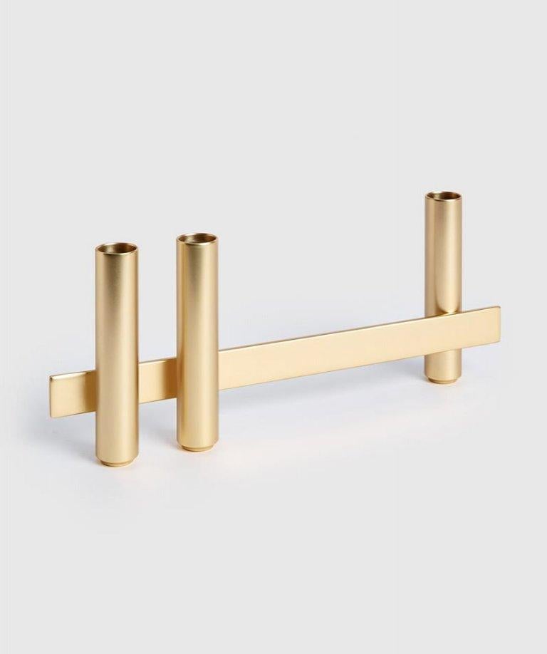 Gold candle holder by Mason Editions
Dimensions: 31 × 5 × 10 cm
Materials: iron
Colors: black, matte 24K gold, cotto, sage green and light grey.

Consisting of a longitudinal metal bar supporting cylindrical elements on both sides, Petit is an