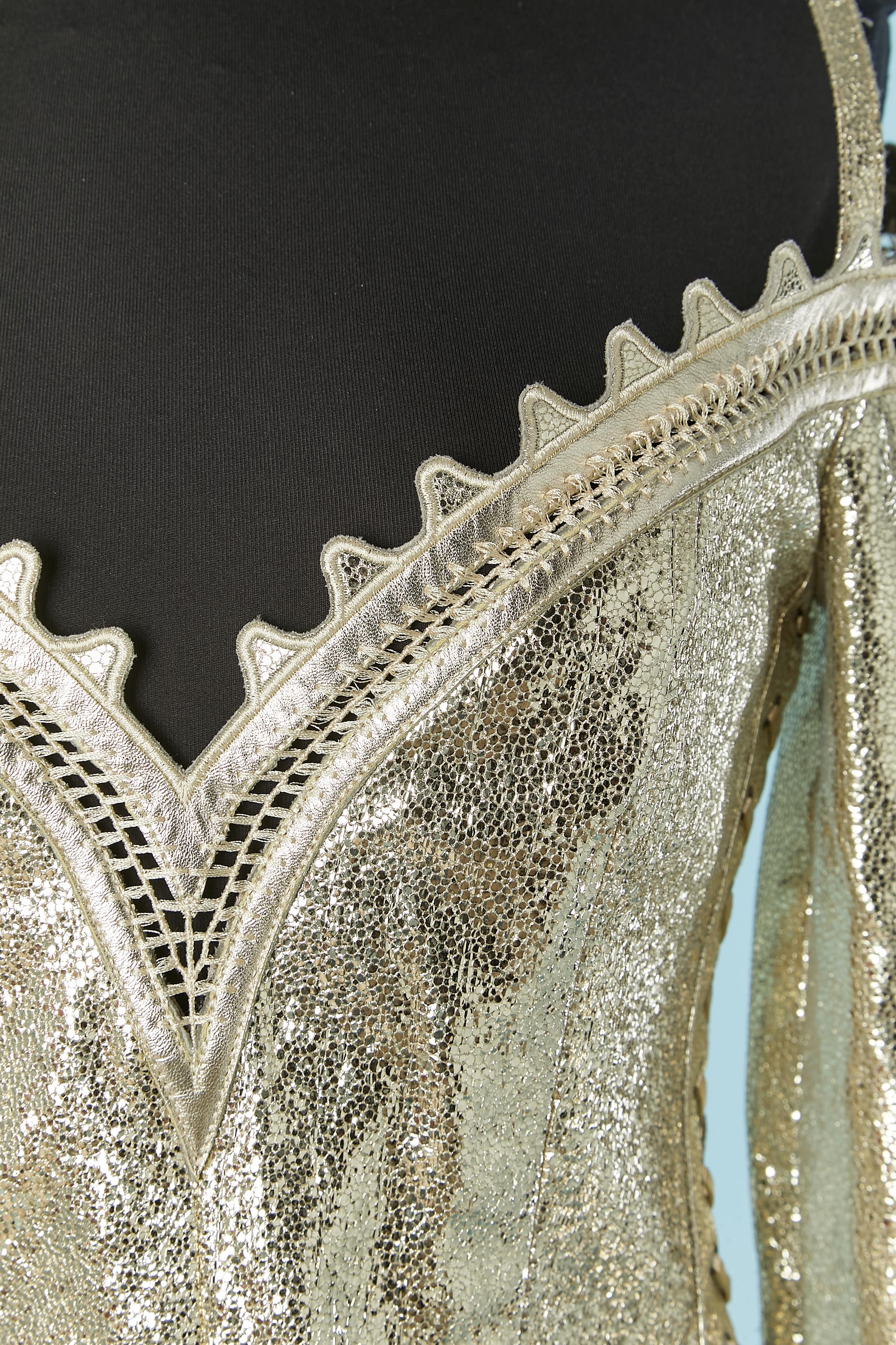 Bustier in pelle caviale oro con lacci laterali. La pelle è rivestita all'interno con una fodera in cotone ( 97% cotone, 3% elastan) Bustier disossato all'interno in tulle elasticizzato ( 82% poliammide, 18% elastan)
Chiusura con zip al centro della