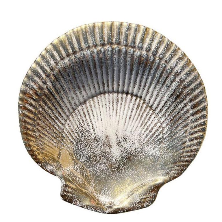 A pretty ceramic sea shell dish in gold and cream. This piece is made of ceramic, and would be fabulous for use as a change dish, trinket dish on a coffee table, or for jewelry on a dressing table or night stand. The top is scalloped on both the
