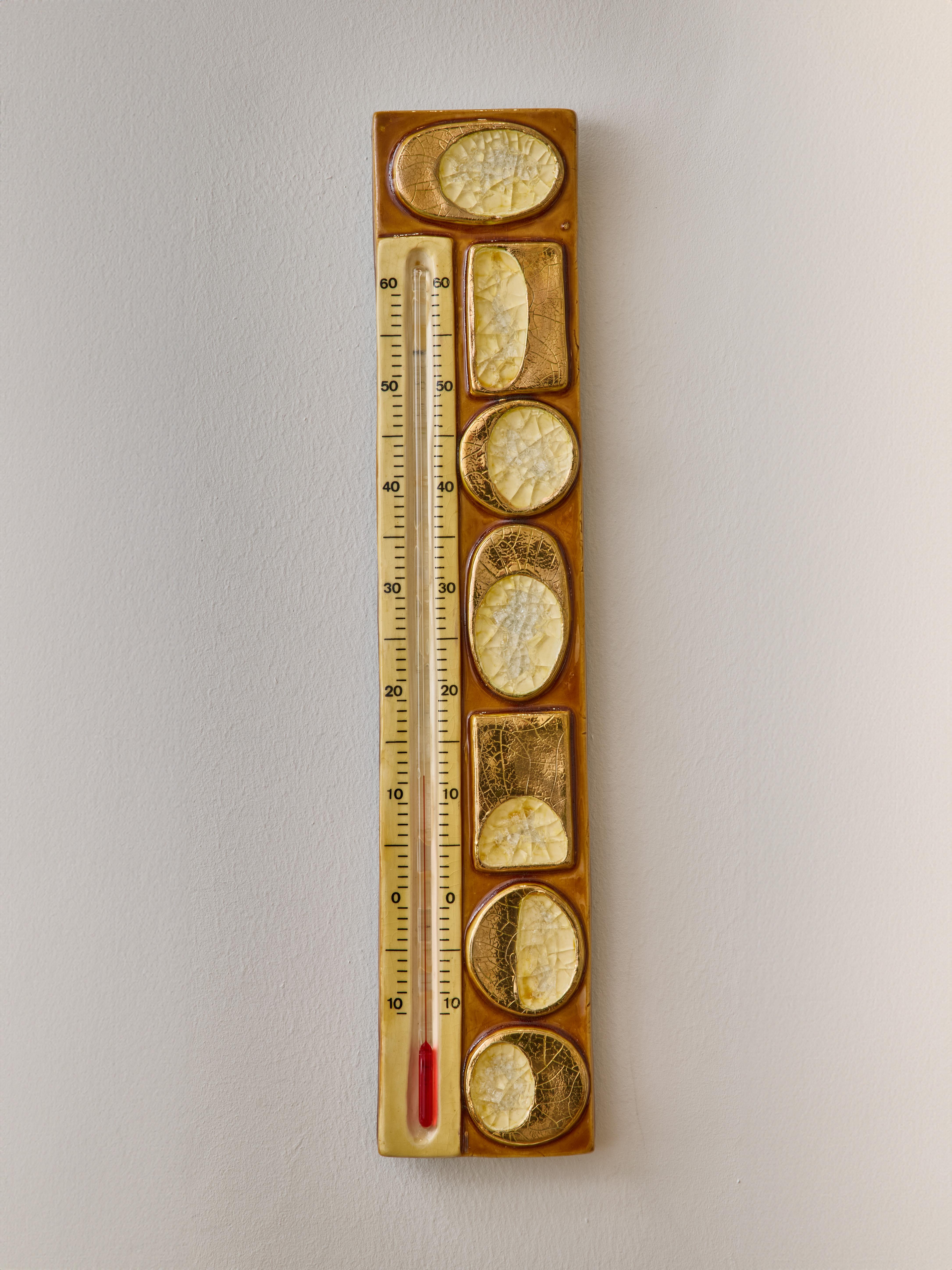 Magnifique thermomètre mural en céramique de Mithé Espelt. Décors abstraits avec glaçure dorée et poches de verre fondu

 

Marie Thérèse Espelt, alias Mithé Espelt (1923-2020)

 

Née à Townes, près de Montpellier, Mithé Espelt a commencé sa