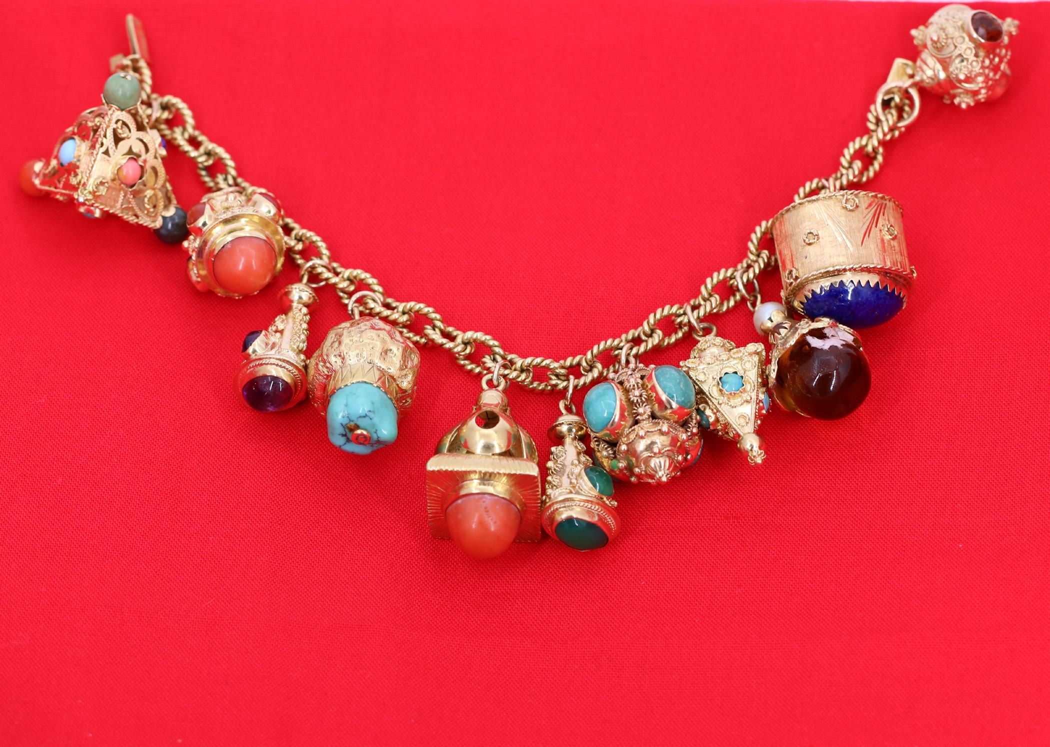 A ladies 18K yellow gold, twisted rope design bracelet signed Weingrill, with eleven Etruscan revival charms. The bracelet gets a rainbow of color from the combination of semiprecious gemstones and glass. Measuring 7 1/2 inches long, it can fit a