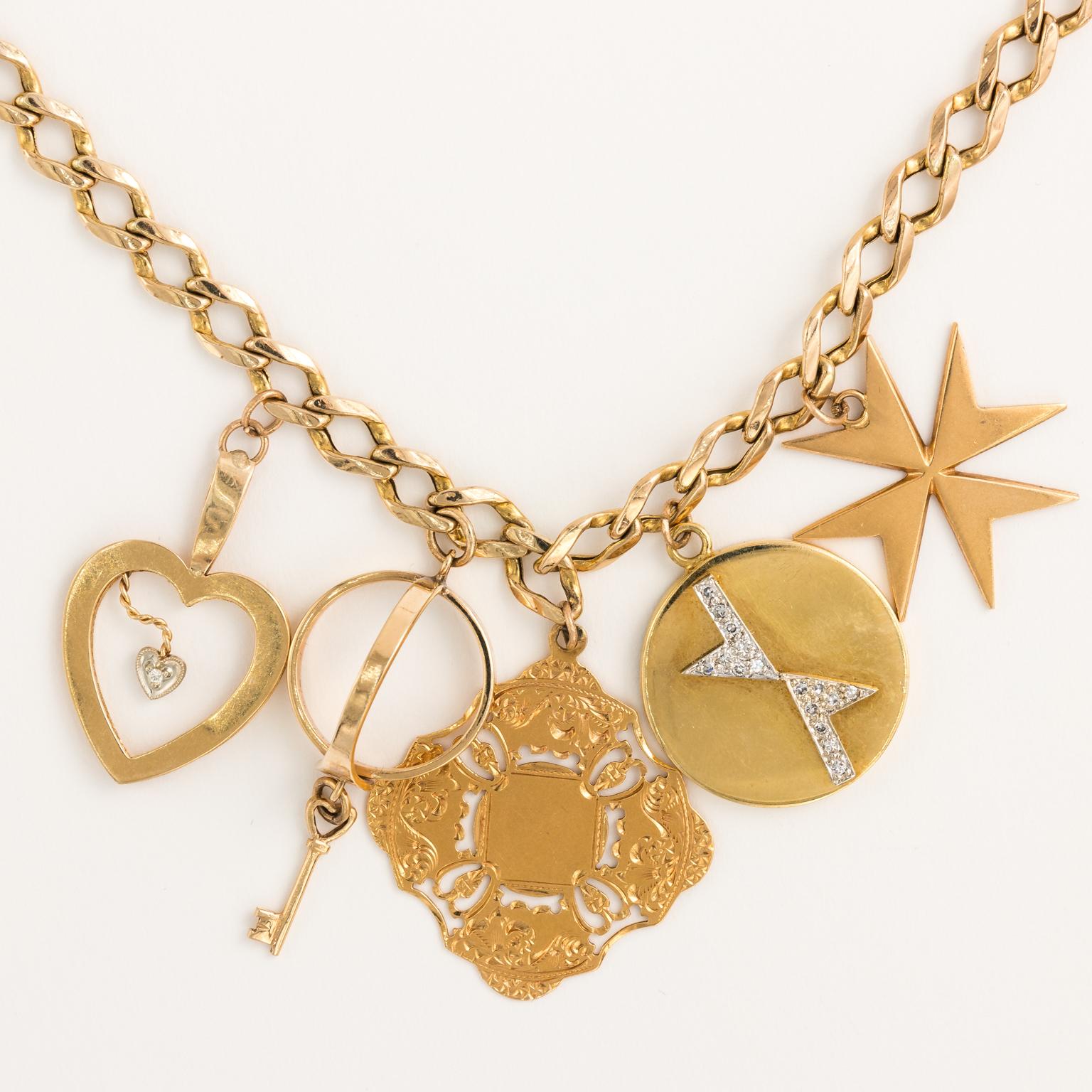 Circa 1940s 14 karat pocket watch chain with five charms including: a 14 karat star charm, an 18 karat chastity belt and key, an 18 karat round charm with 0.25 pt diamond design, and a late Victorian 18 karat repousse charm that can be engraved.
