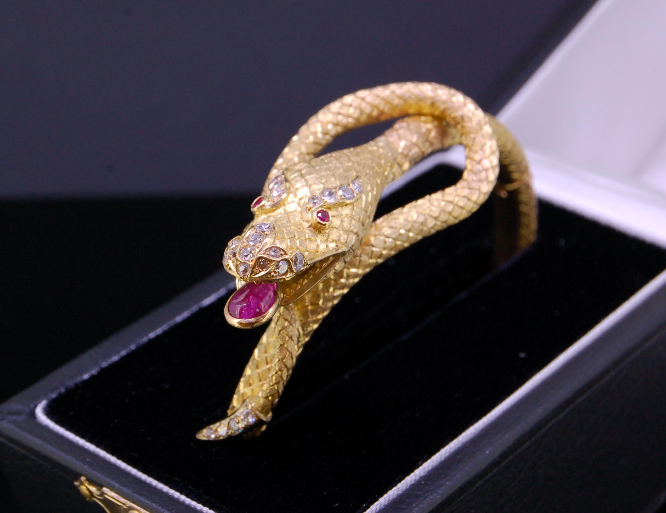 GOLD CHINESE DRAGON BANGLE, in yellow precious metal. The tongue set with a ruby of 1.29 ct. and diamond accents on the nose and eyes. The bangle overall with dragon skin pattern. Inner diam. 6.3 cm. 69.5 grams. With a fitted box.
