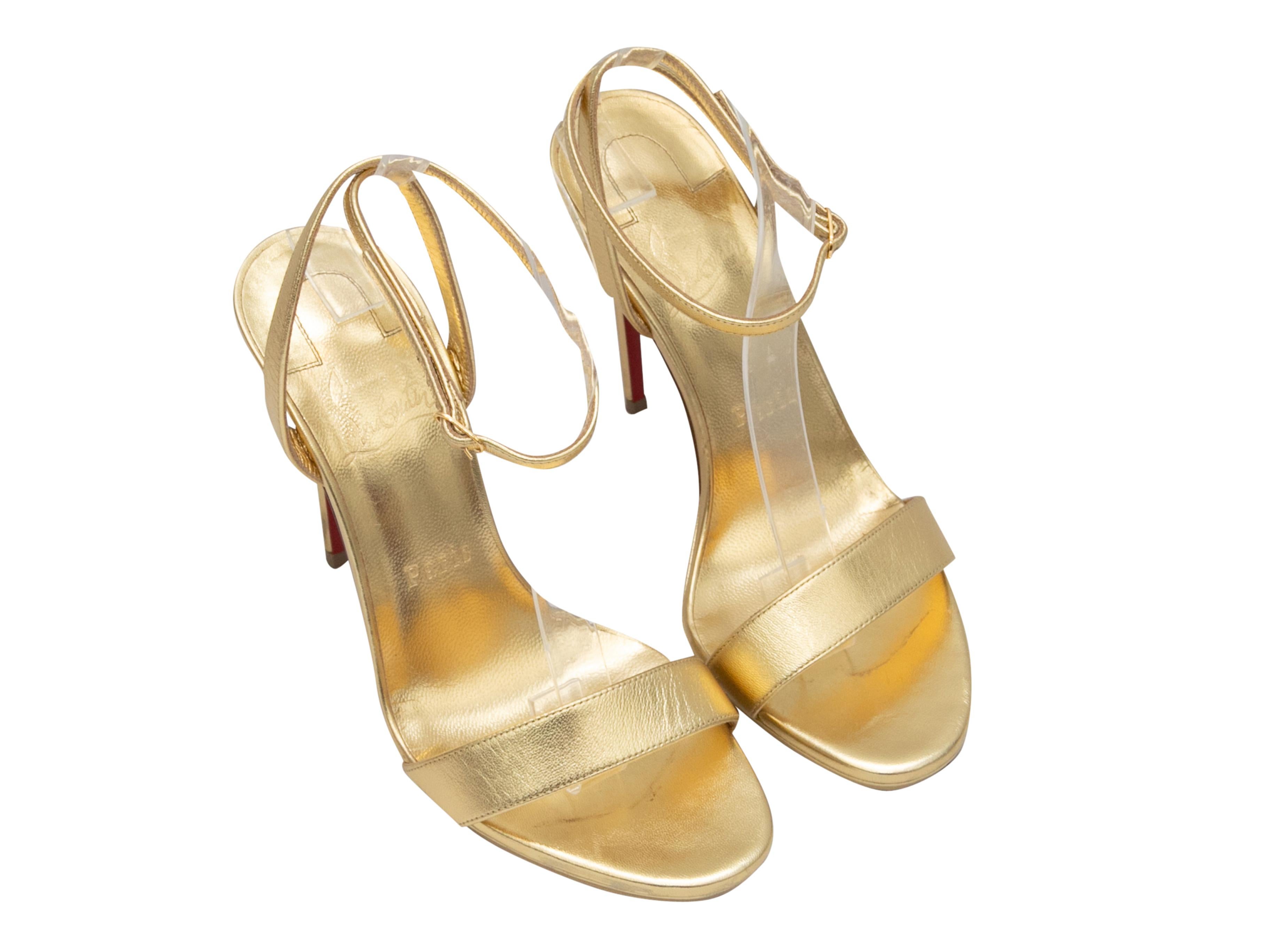Gold metallic leather heeled sandals by Christian Louboutin. Buckle closures at ankle straps. 4.5