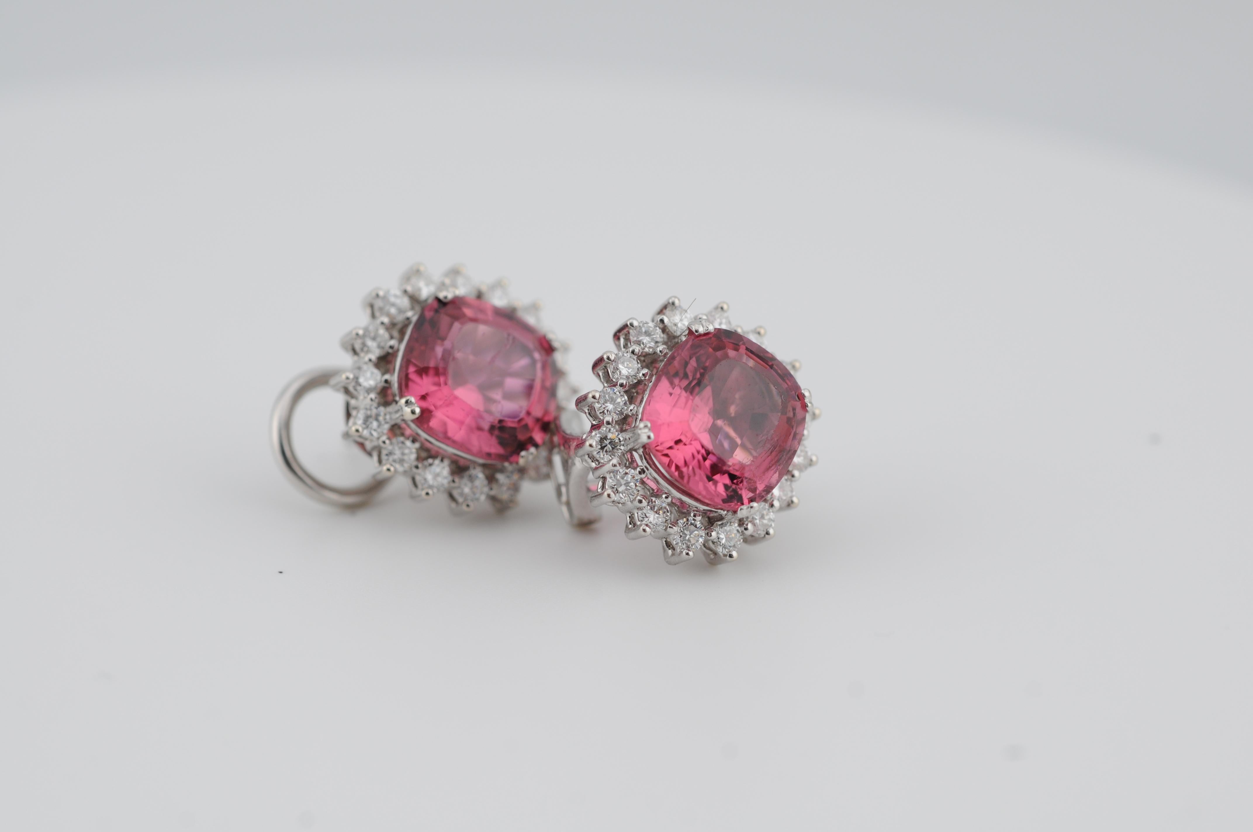 Exquisitos pendientes de clip de oro blanco de 18 quilates con dos vívidas turmalinas rosas en talla cojín, cada una con un peso aproximado de 3,00 quilates. Rodeados por un halo de 16 diamantes talla brillante por piedra, estos pendientes logran un