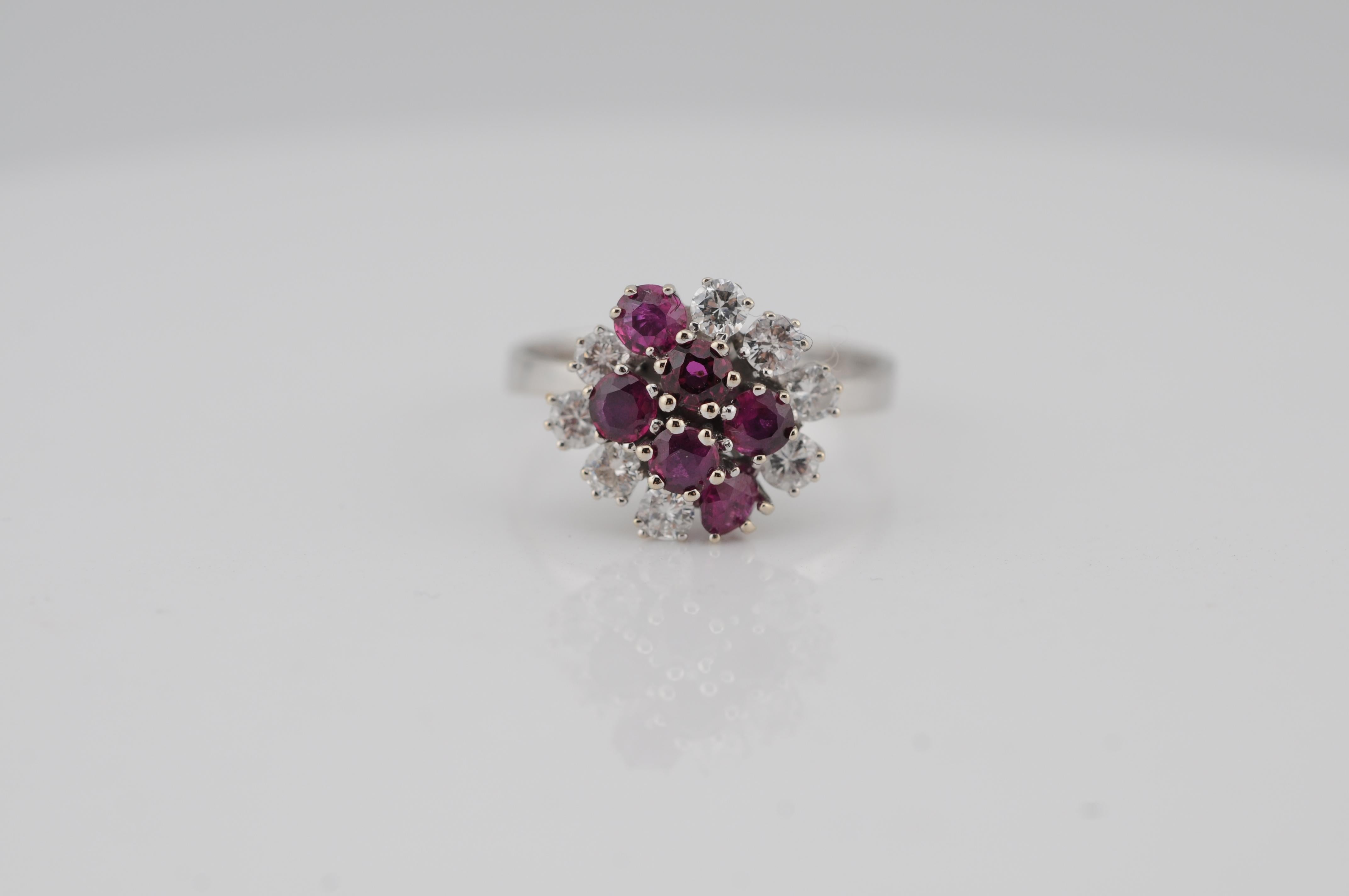 Eleganter Clusterring aus 14 Karat Weißgold. Der Ring ist mit 6 natürlichen Rubinen von insgesamt 1,06 Karat besetzt, die von 8 Diamanten im Brillantschliff mit einem Gesamtgewicht von 0,61 Karat hervorgehoben werden. Ein raffiniertes Design mit
