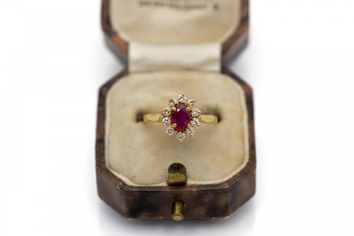Anello in oro vecchio con rubino di colore rosso intenso e un peso impressionante di 0,55 ct. 

Anello con 10 diamanti taglio brillante da 0,28 carati, colore F e purezza VS-SI. 

Realizzato in oro giallo 18 carati.

Origine: Francia, metà del XX