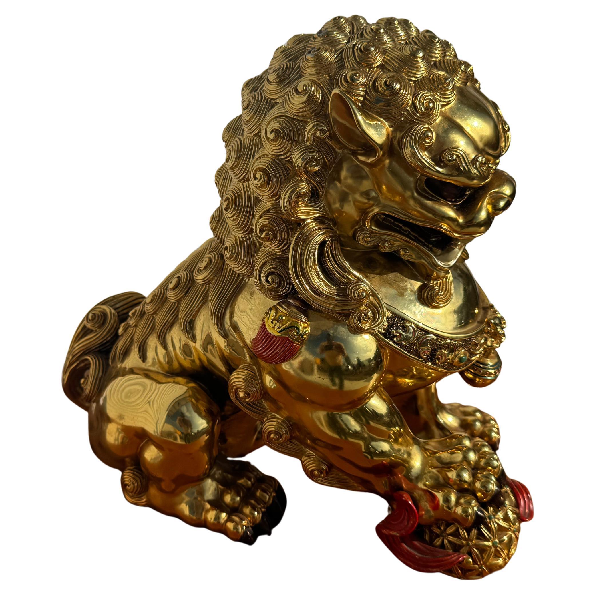 Questo leone Foo è stato realizzato in Cina ed è rivestito d'oro...
È realizzato in porcellana ed è finemente dettagliato.
La zampa del Foo Lion poggia su una palla rossa.
Ha degli accenti rossi.