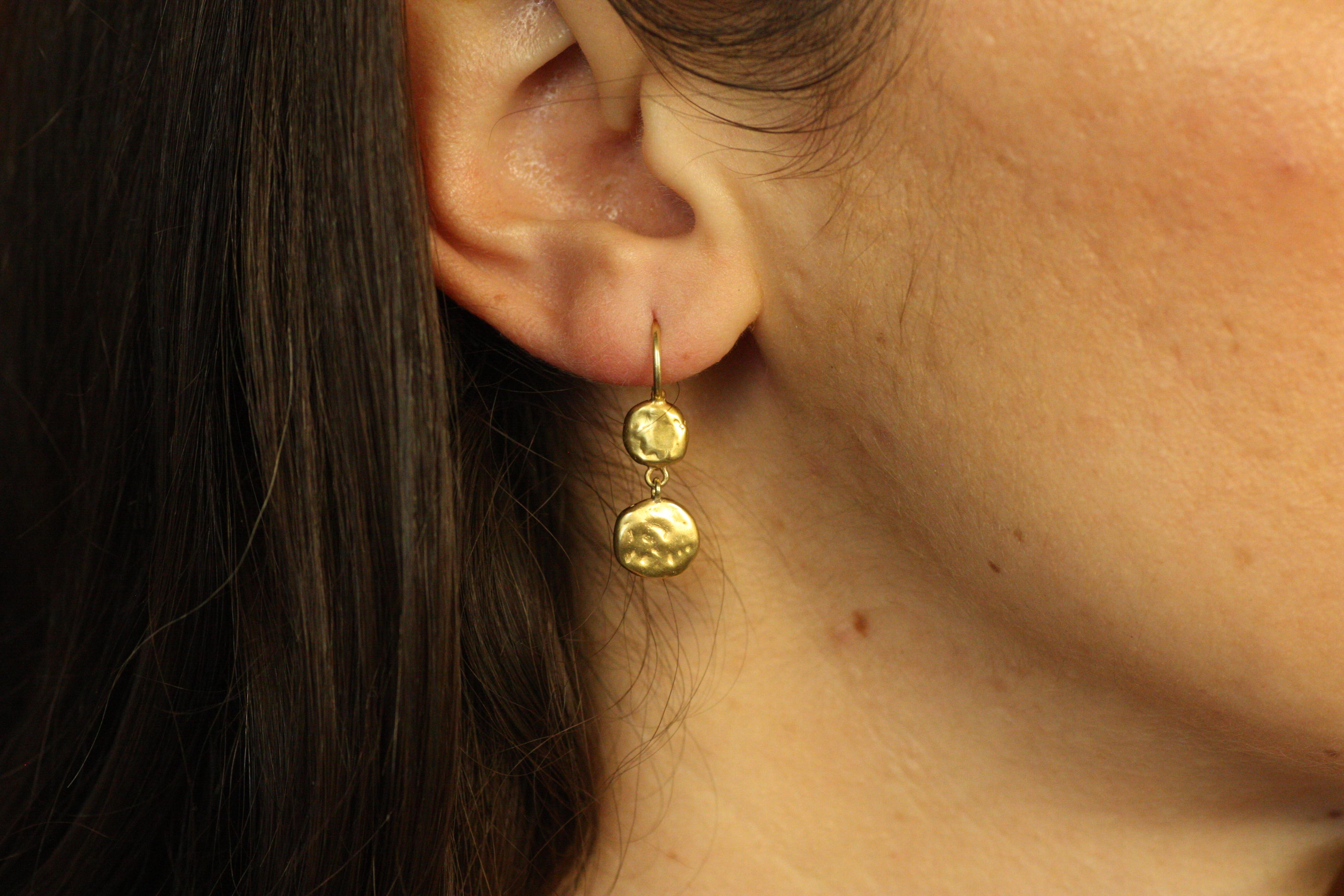 Ces boucles d'oreilles en or 18 carats en forme de pépites de monnaie sont un mélange unique de design organique et de style intemporel. Reliés par de petits maillons, les ronds pendent naturellement, offrant une beauté et un intérêt vraiment