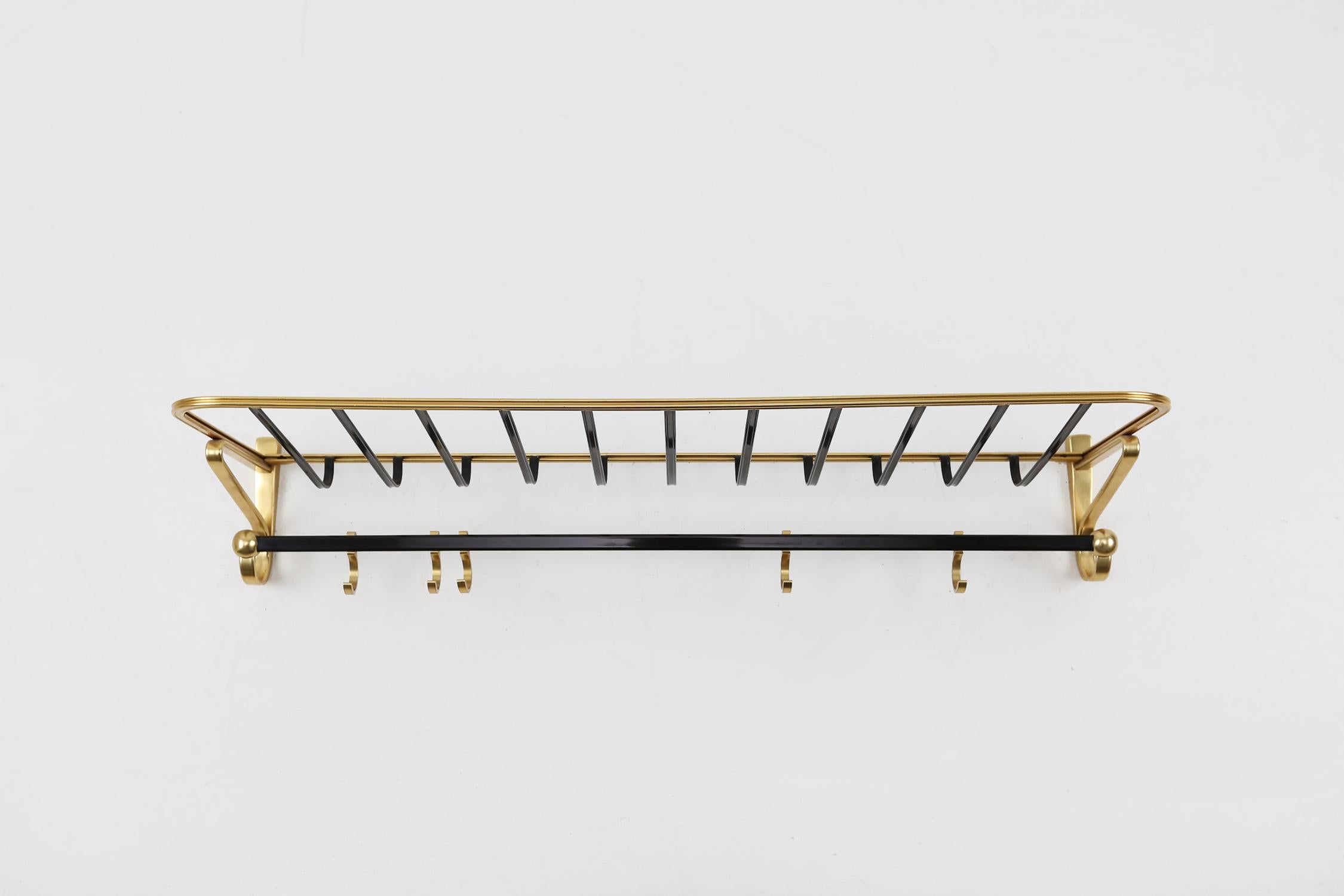 Mid-century coat rack made of aluminium in gold and black color.
Racks are adjustable from left to right.