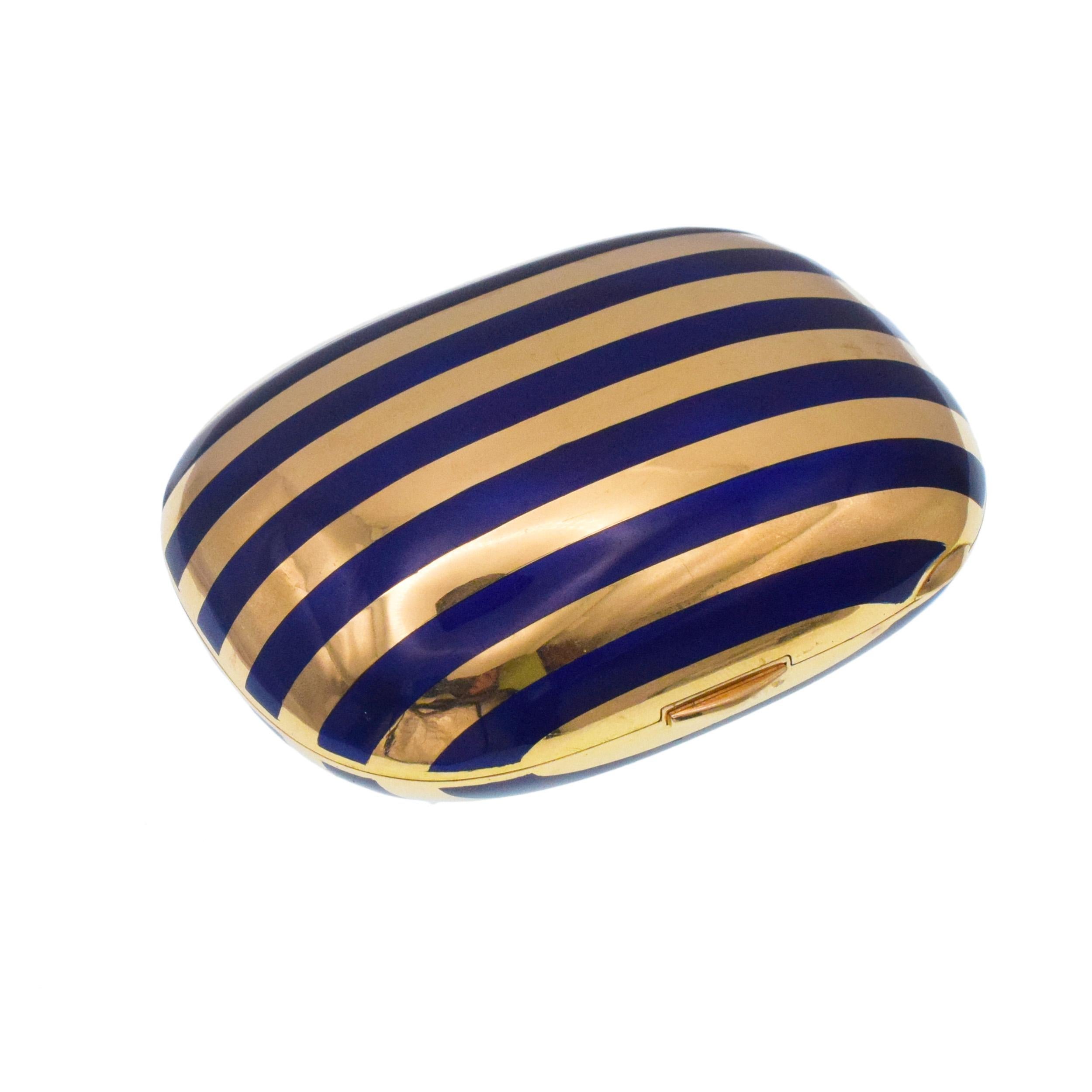 Striped Blue Enamel Pill Box In 18k Yellow Gold. 
Inside of the lid inset with the mirror. Equipped with push button closure. Inscribed: Made in Italy. Stamped: 750 and makers marks. Measurements: 78mm x 58mm (3 inches x 2.3 inches). Depth: 33mm