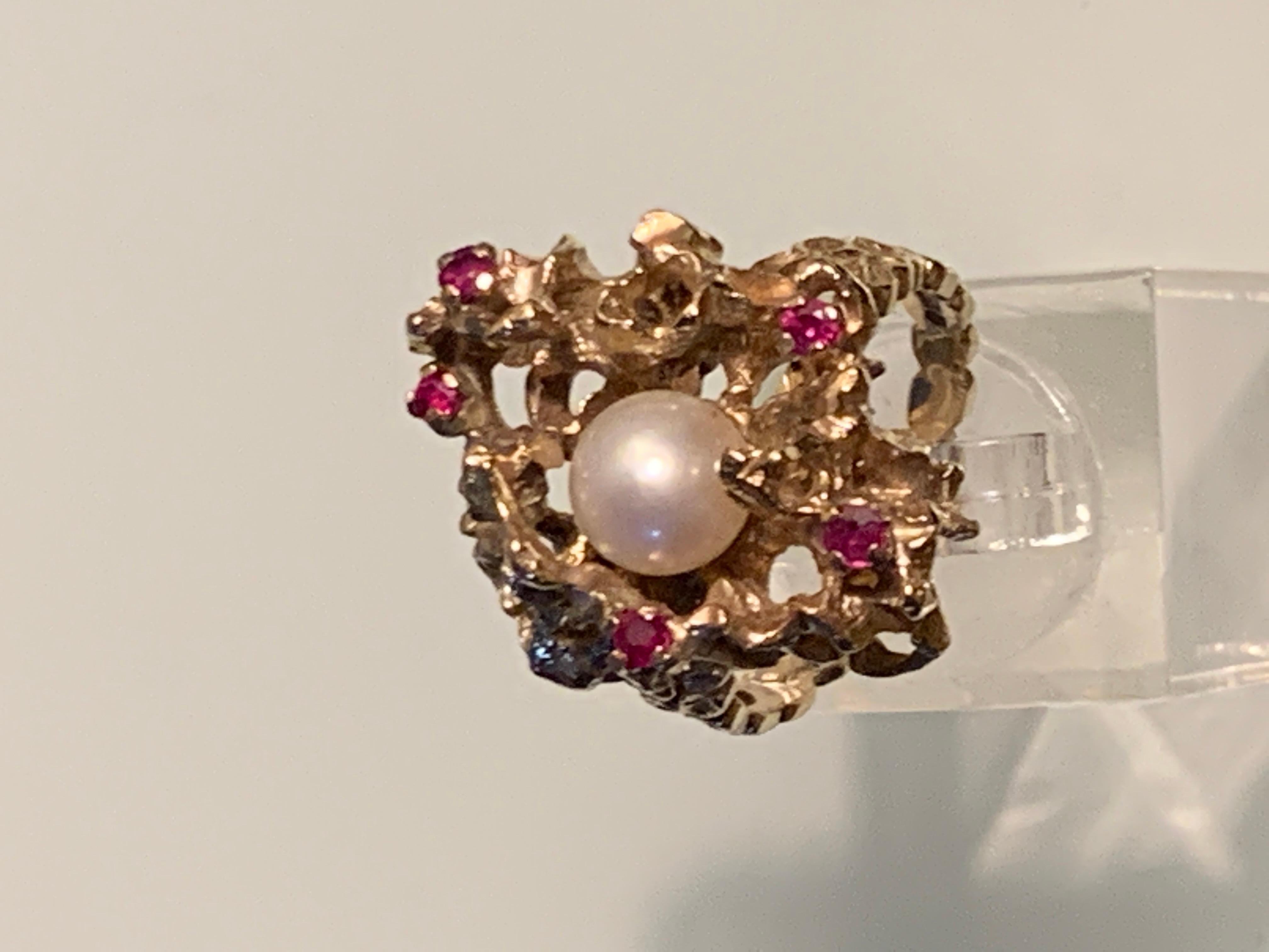 Mid Century Design
9ct Gold Coral design Central Pearl and Rubies.

Central Cultured pearl size - 7.5mm ( milimeters)

Rubies x 5  size - 2.5mm (millimeters)

Size - 18mm ( inner diameter )
U.K - P 1/2
U.S - 7 3/4

Fully Hallmarked (British)
Dated