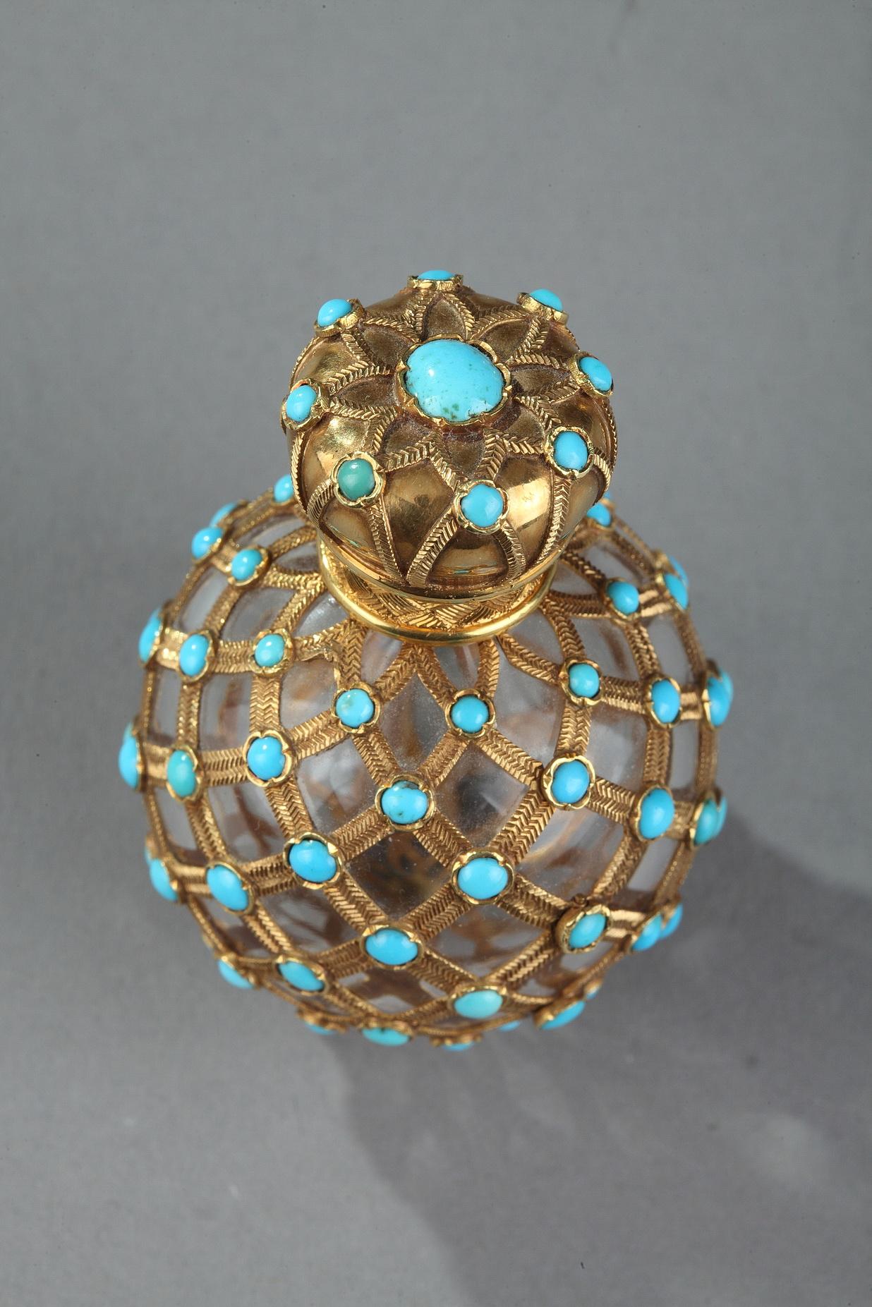 Round Perfume flask set in a finely chiseled gold mesh and enhanced with half turquoise pearls mounted in a cabochon. The Hinged cover decorated with the same gold and turquoise mesh.
Gold cap inside.
Gold mark: giraffe head 1835-1838.