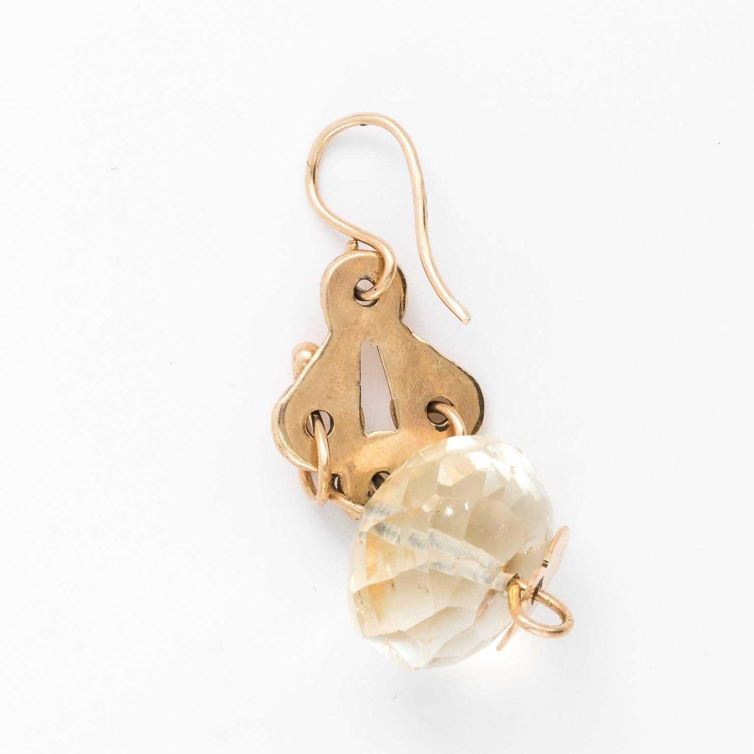 Circa 1960 artisan made earrings in 18 karat gold with faceted citrine, by a jeweler in Cap Cod. The earrings feature intersecting circles with gold loops and leaf shaped motifs.
