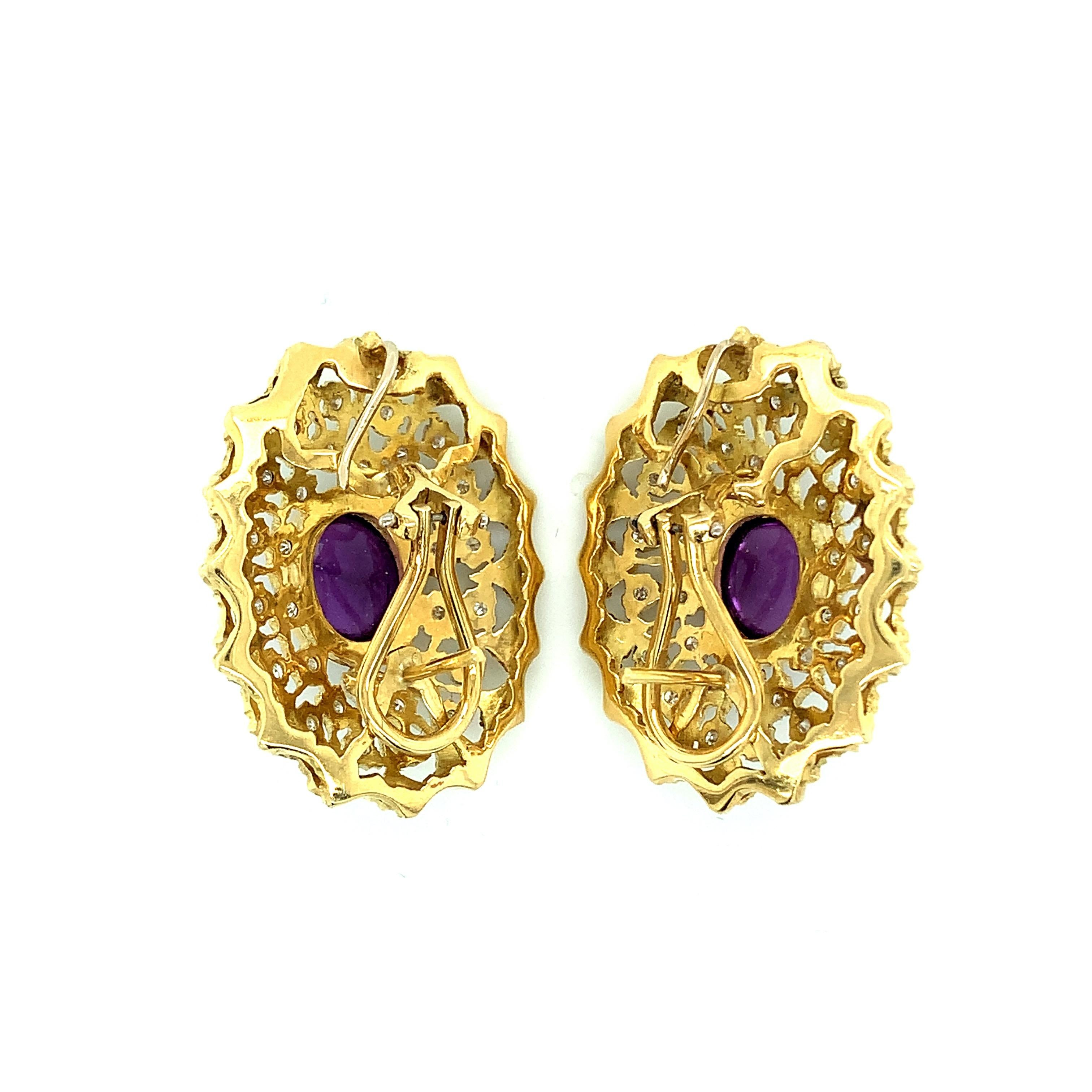 A pair of oval shaped earrings featuring round cut diamonds and a cabochon amethyst at the center. Set in 18 karat yellow gold and white gold. The diamonds weigh approximately 2 carats and the amethysts weigh approximately 10 carats. Total weight:
