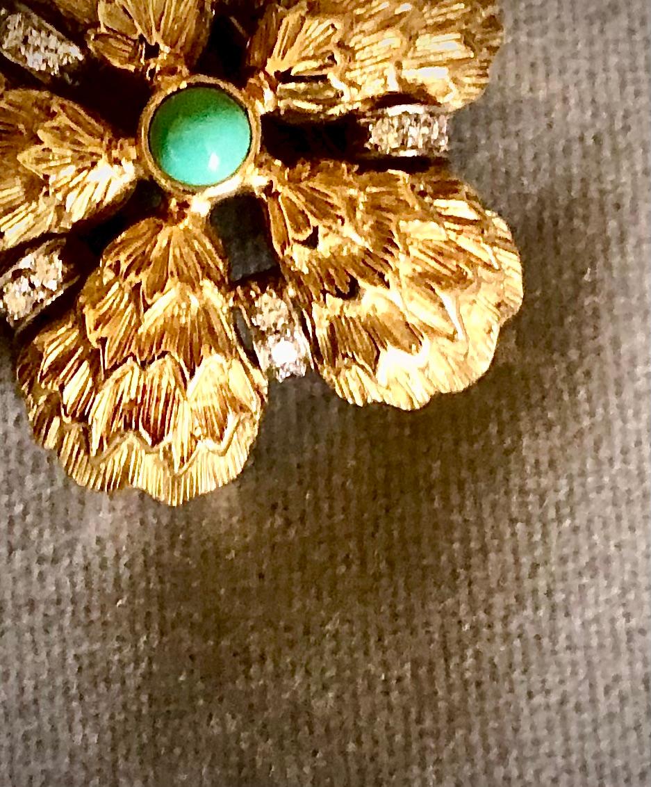 Schöne und kräftige Brosche aus 18kt Gold. Die Brosche selbst ist in einer fünfblättrigen Form mit einem Mittelstein aus sehr feinem Türkis modelliert. Die Segmente der Blütenblattform sind durch Rauten unterteilt. Jede Abteilung besteht aus drei