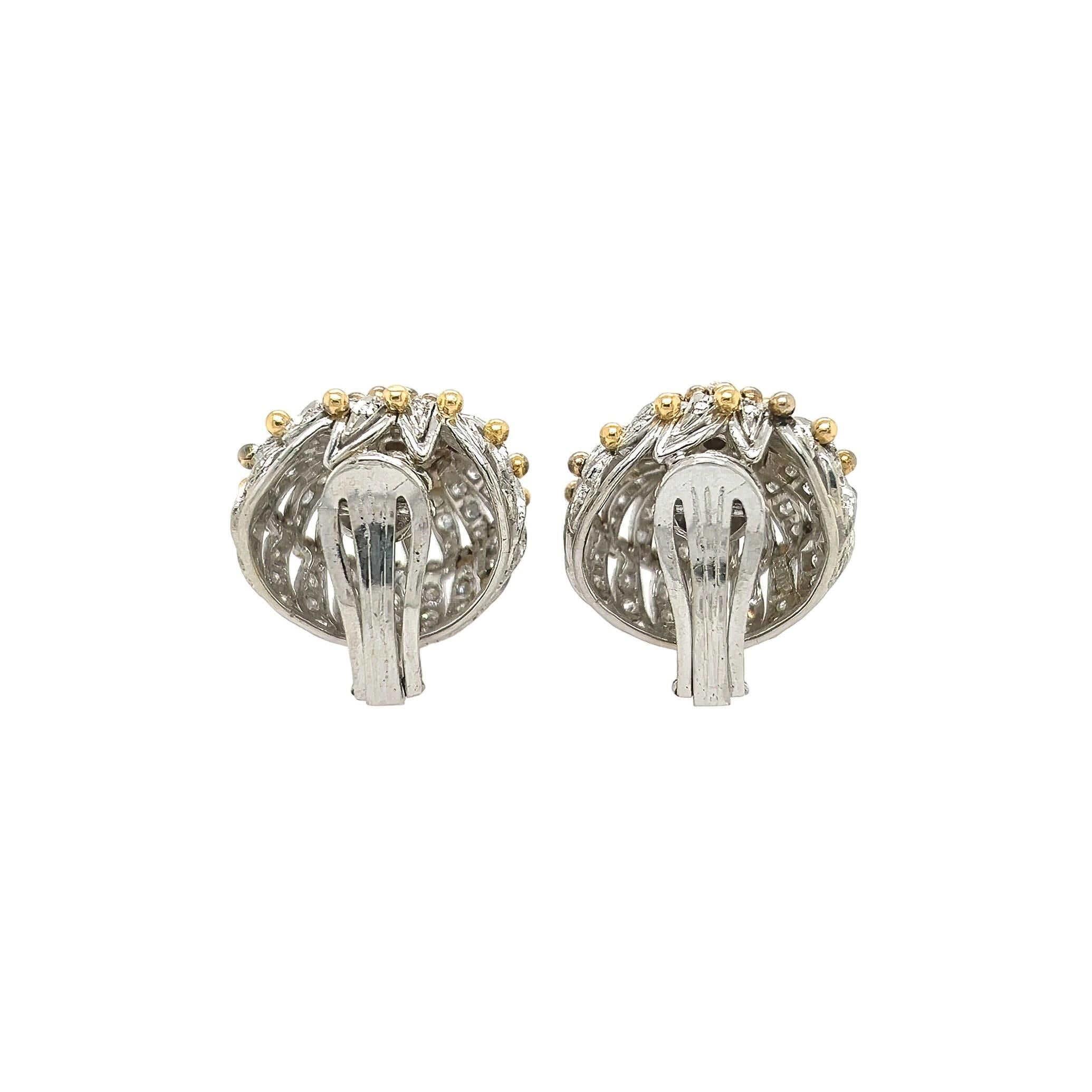 A pair of platinum, 18 karat yellow gold and diamond earclips, with 14 karat white gold clips.  Each platinum earclip designed as a milgrain openwork spiral set with approximately 80 single cut diamonds, centering a cluster of six round brilliant