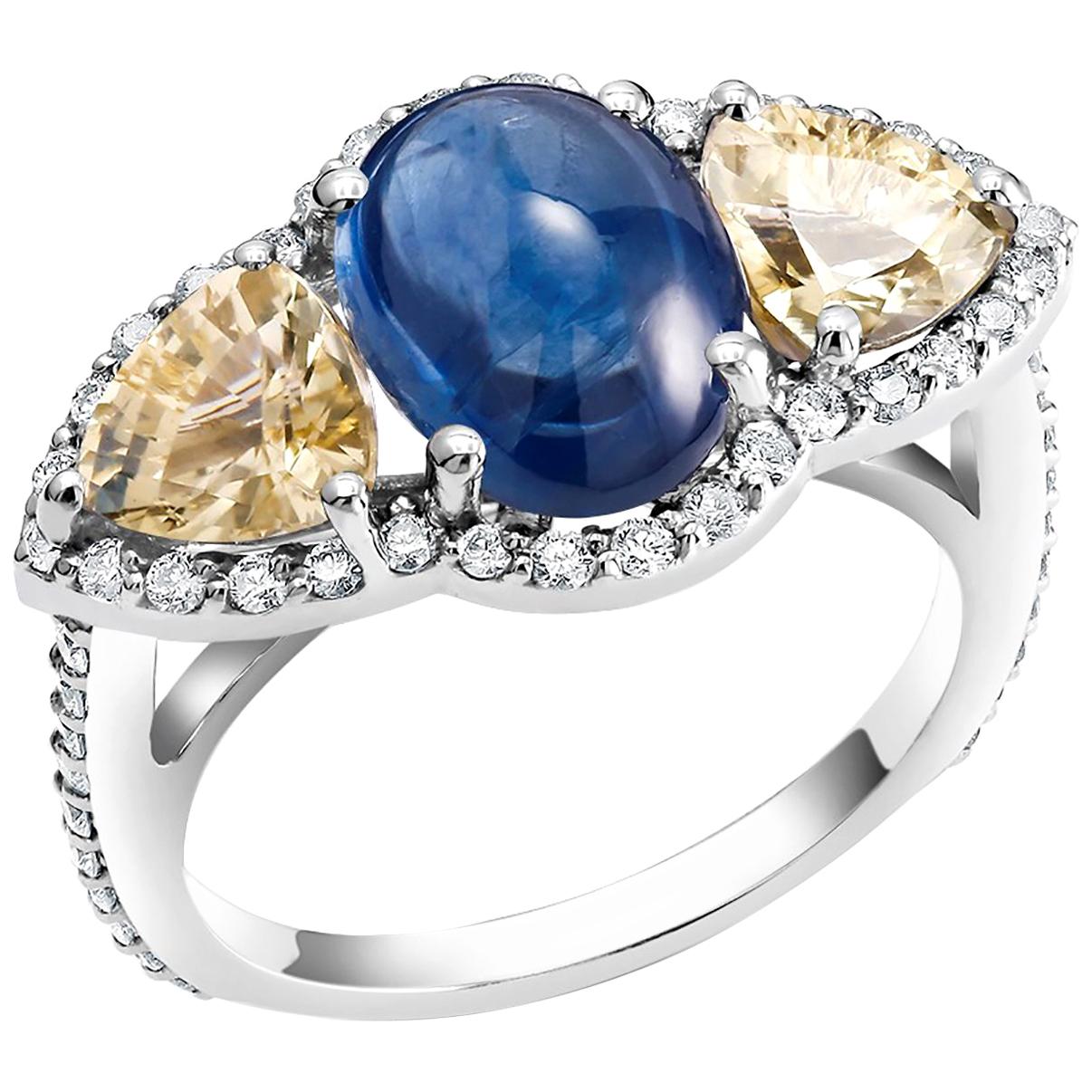 Eighteen karats white gold cocktail ring
Cabochon sapphire weighing 4.07 carat 
Two triangle yellow sapphires weighing 1.90 carat
Surrounded by pave-set diamonds weighing 0.80 carat
Diamond quality G VS
New ring 
Ring finger size 6 In Stock
The ring