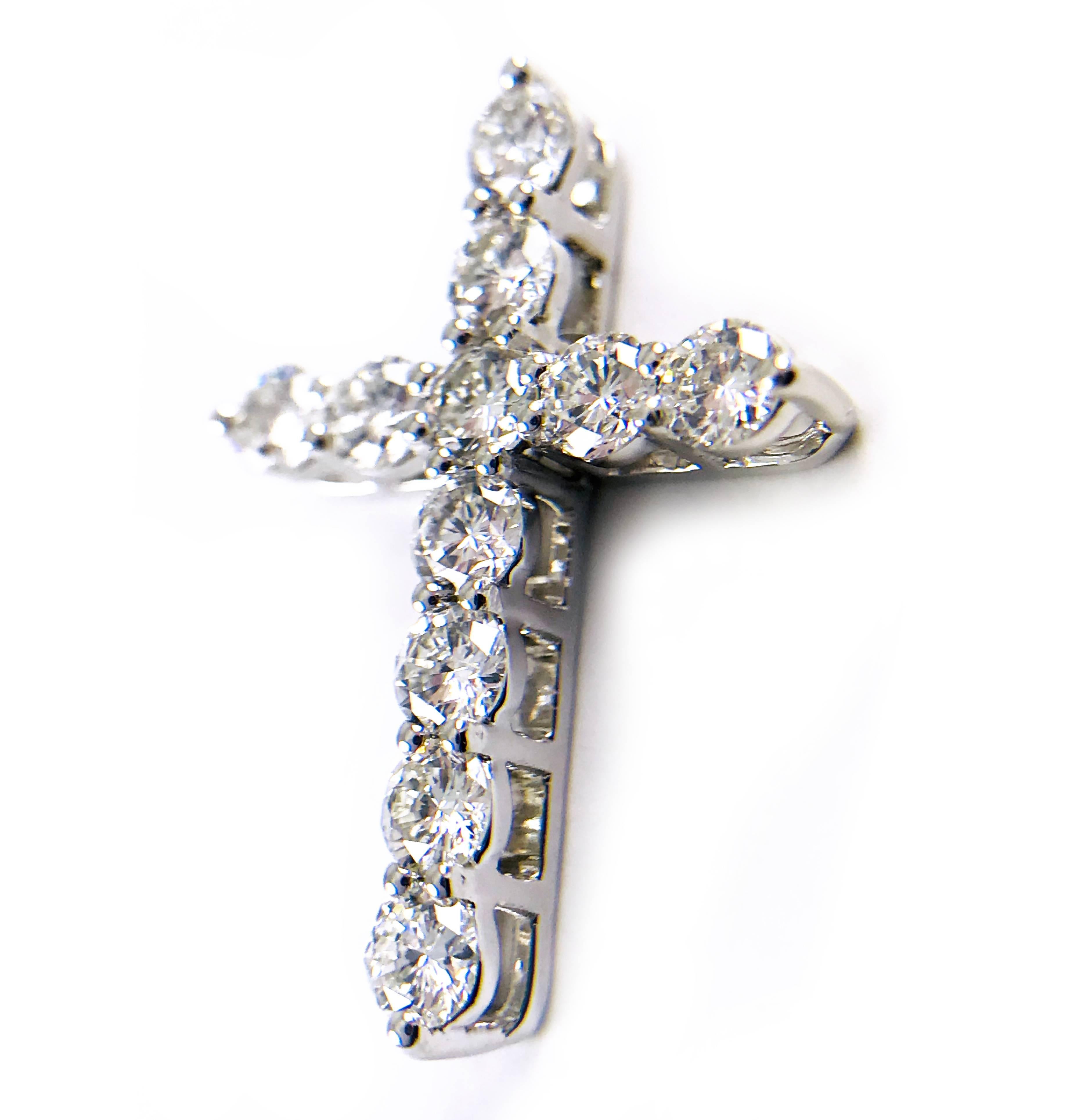 New 14k white gold diamond cross pendant adorned with eleven round brilliant cut diamonds. The diamonds are prong-set in basket-style mountings that allow light to flow through the diamonds for ultimate sparkle and brilliance. Diamonds are VS1 in