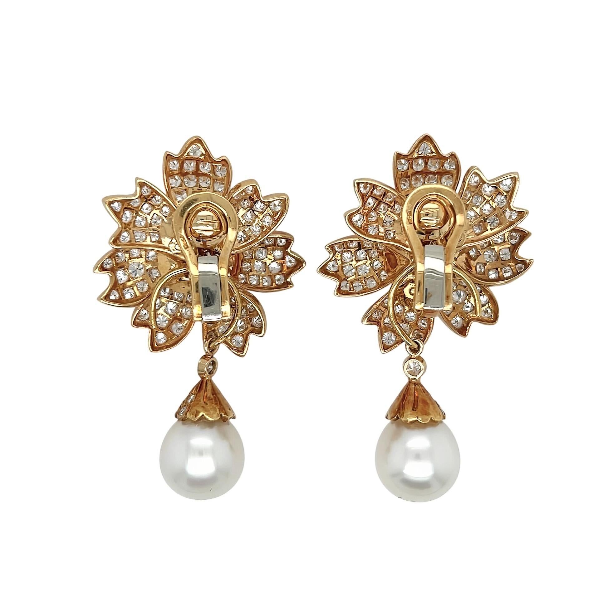 Un par de pendientes de oro amarillo de 18 quilates, perlas y diamantes.  Cada pendiente está diseñado como una flor engastada con aproximadamente 92 diamantes talla brillante redondos que suspenden una perla desmontable que mide aproximadamente