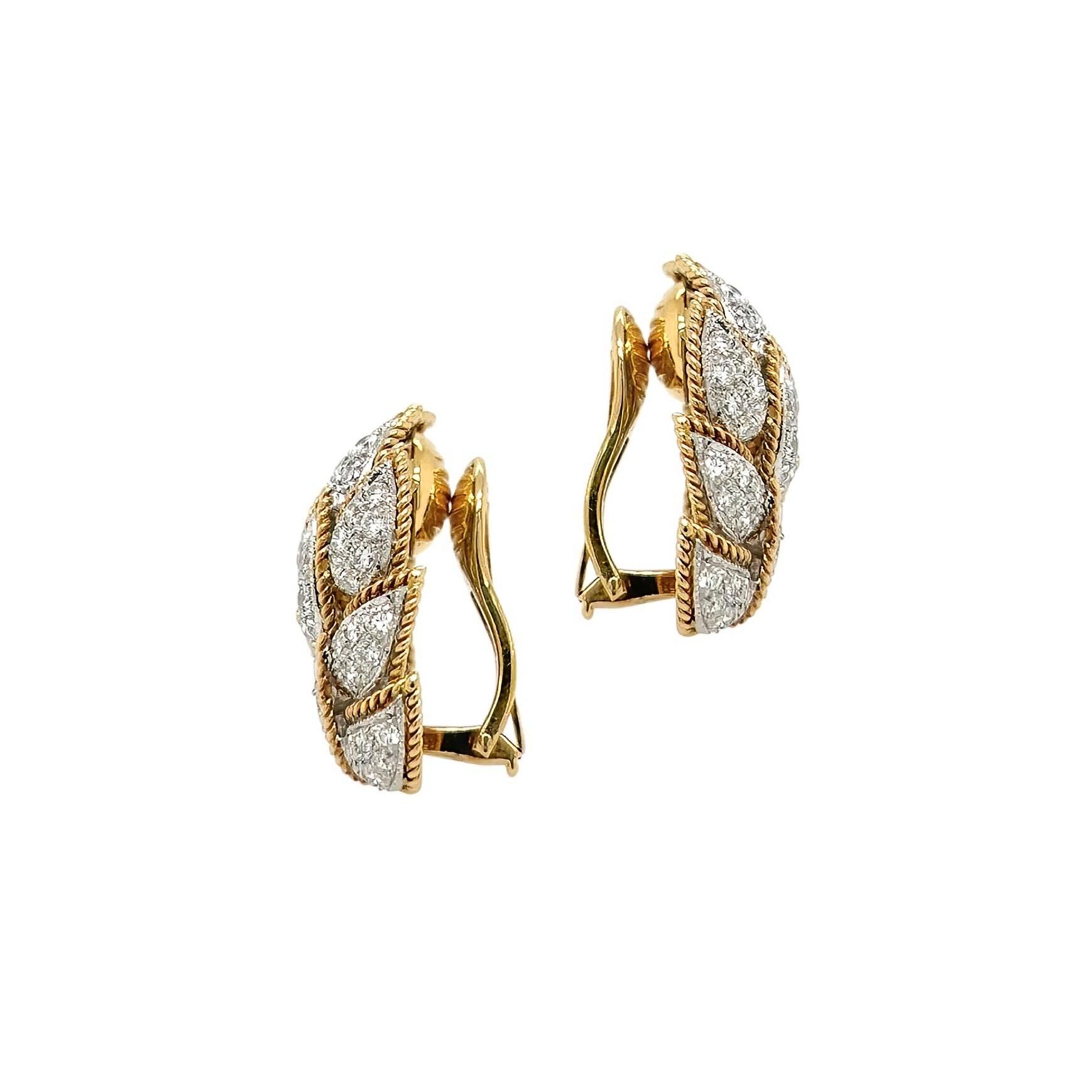 A pair of 18 karat yellow and white gold and diamond earclips.  Each earclip designed as a cluster of 11 stylized pointed leaves outlined in yellow gold ropework, the leaves set with approximately 65 round brilliant cut diamonds in white gold. 