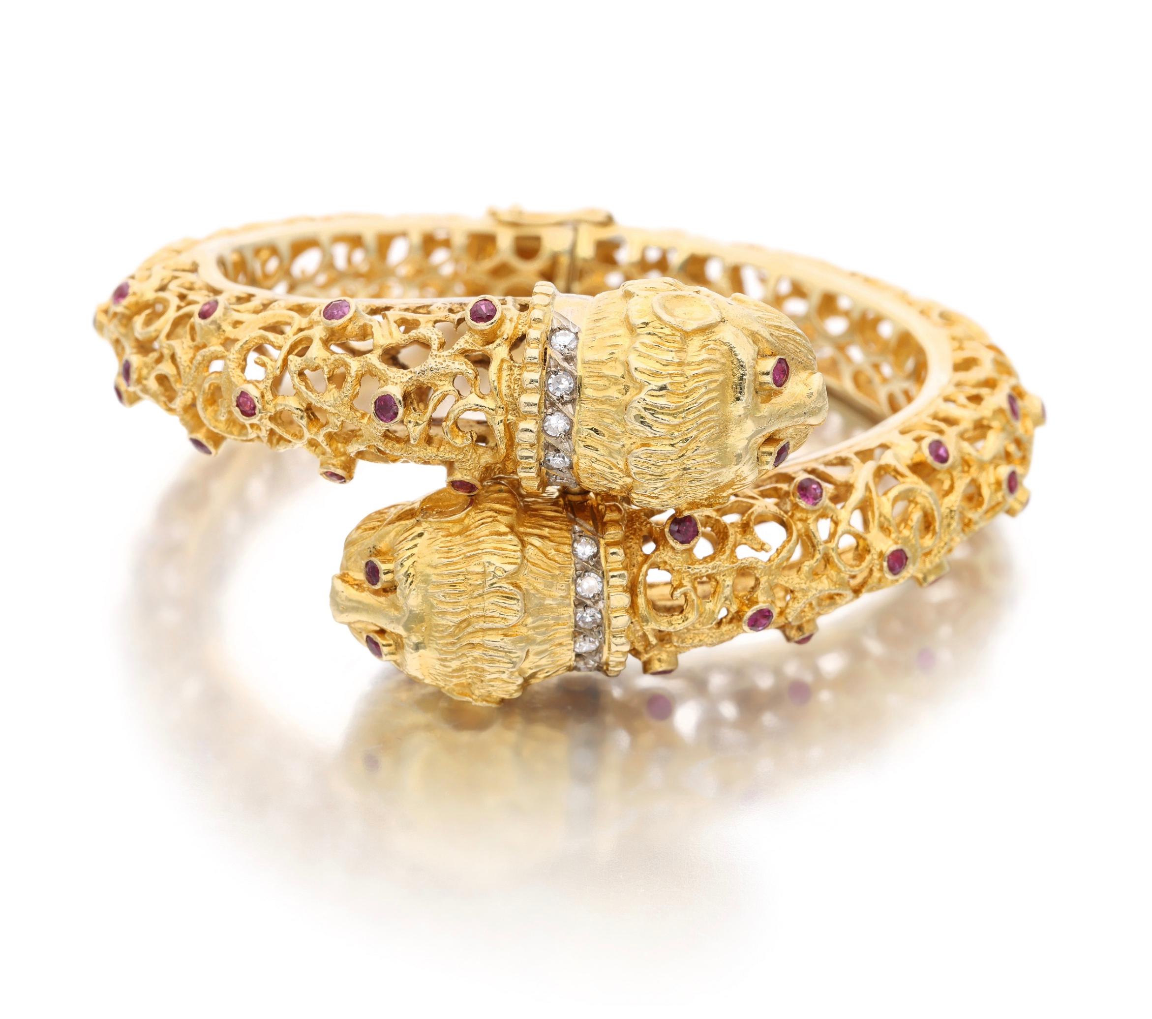 A two-headed chimera bangle bracelet made out of 18 karat yellow gold. It is sprinkled with rubies throughout, weighing approximately 2.70 carats. The necks of the two heads are lined with diamonds, weighing approximately 0.20 carat. Made in Greece.