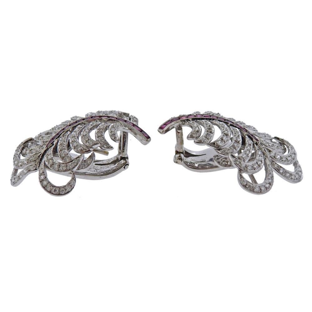Pair of 18k white gold feather earrings, set with rubies and approx. 1.00ctw in diamonds. Have collapsible posts - slightly bent. Earrings measure 36mm x 20mm. Marked 750. Weigh 15.5 grams. Posts slightly bent - collapsible.
