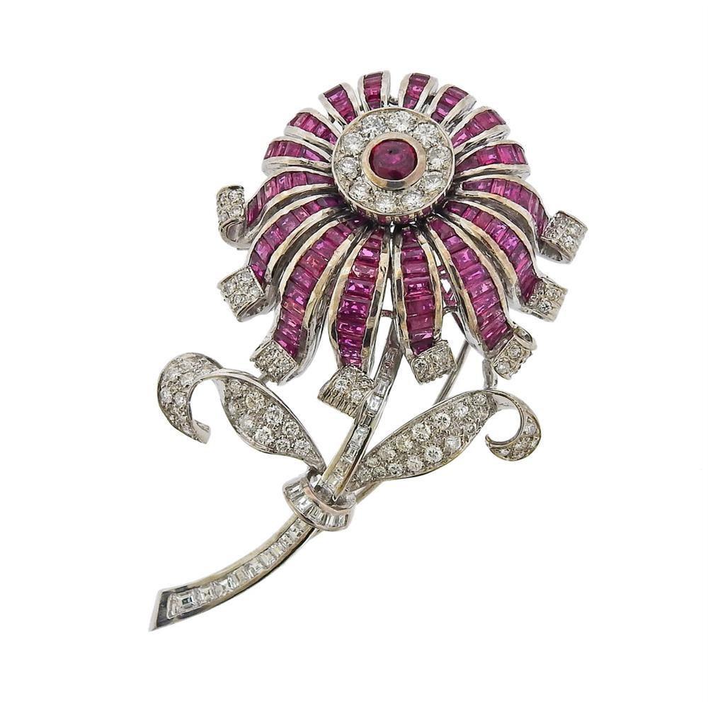 Large 18k white gold flower brooch, set with one approx. 0.50ct ruby in the center, surrounded with more ruby gems and approx. 2.65ctw in diamonds (one small diamond is missing - on the end of the stem of the flower) . Brooch is 65mm x 42mm. Marked