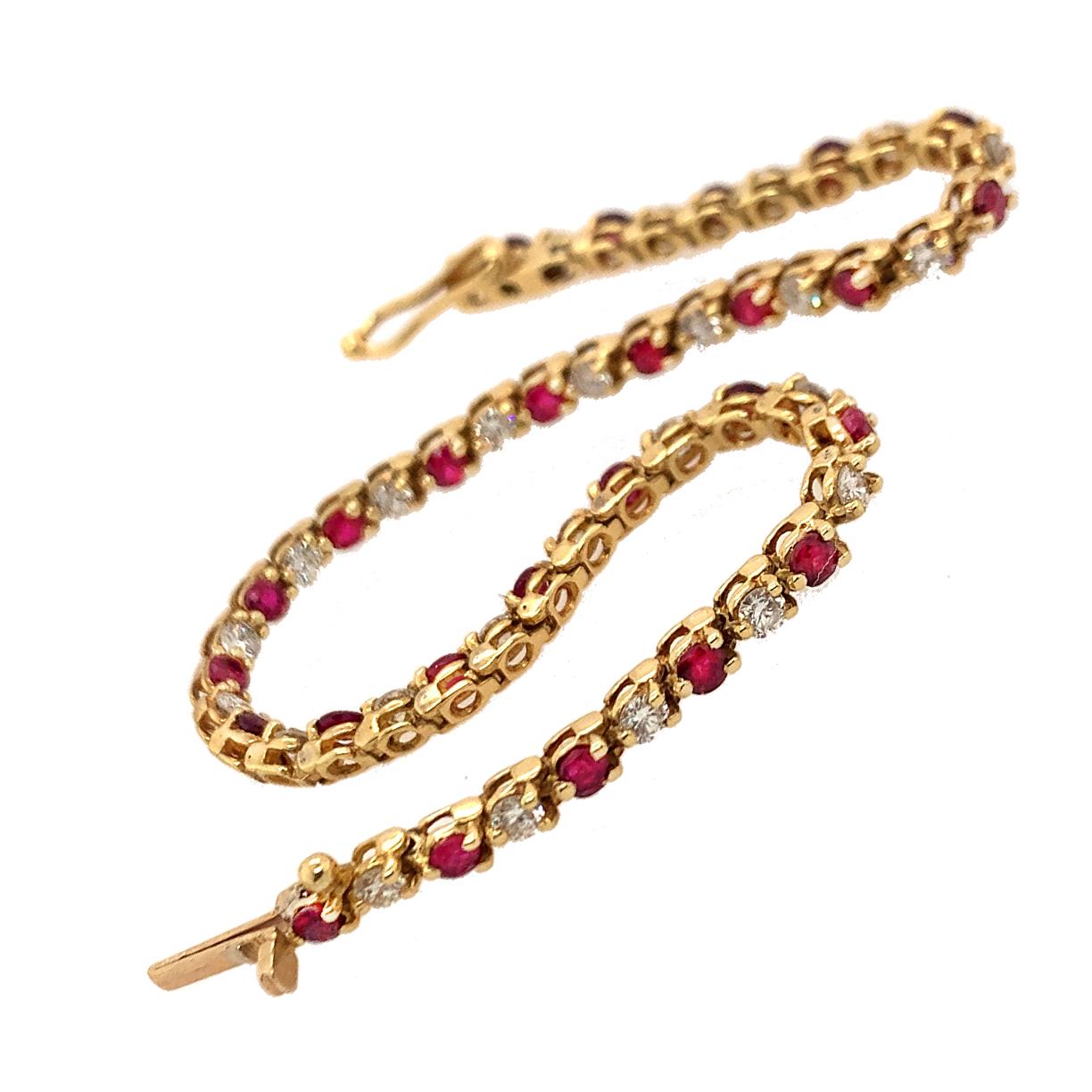 A classic riviere bracelet bracelet with alternating brilliant diamonds and rubies.  Made and signed by TIFFANY & CO.  18K yellow gold.  Approximately 2.34 carats of rubies and 1.56 carats of diamonds (there are 26 of each stone).  Safety clasp. 