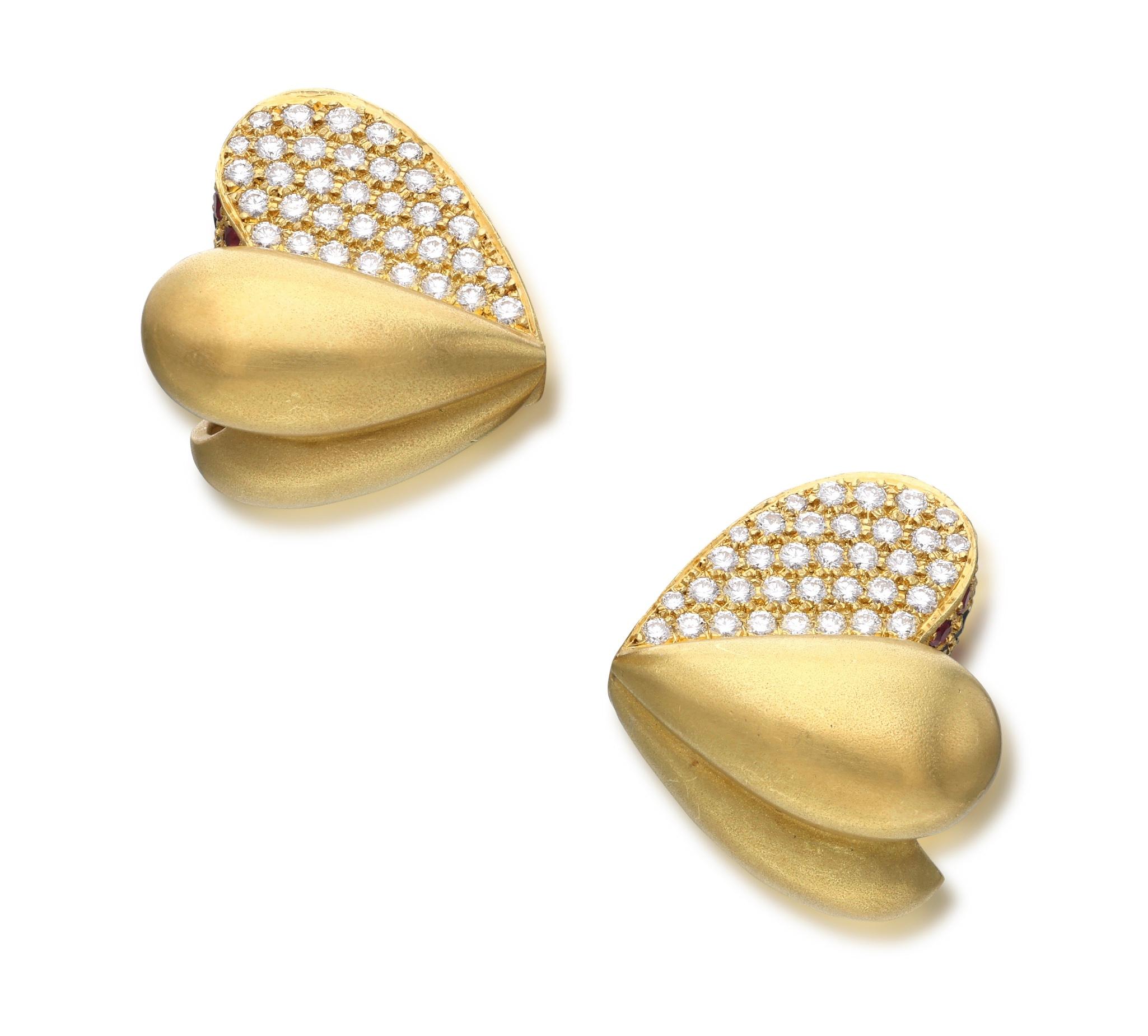 Ces magnifiques clips d'oreilles sont conçus comme un cœur, sertis de diamants ronds, de rubis et de saphirs.

- Les diamants pèsent au total environ 1,40 carat.
- Les rubis et les saphirs pèsent au total environ 2,50 carats.
- Or jaune 18 carats
-