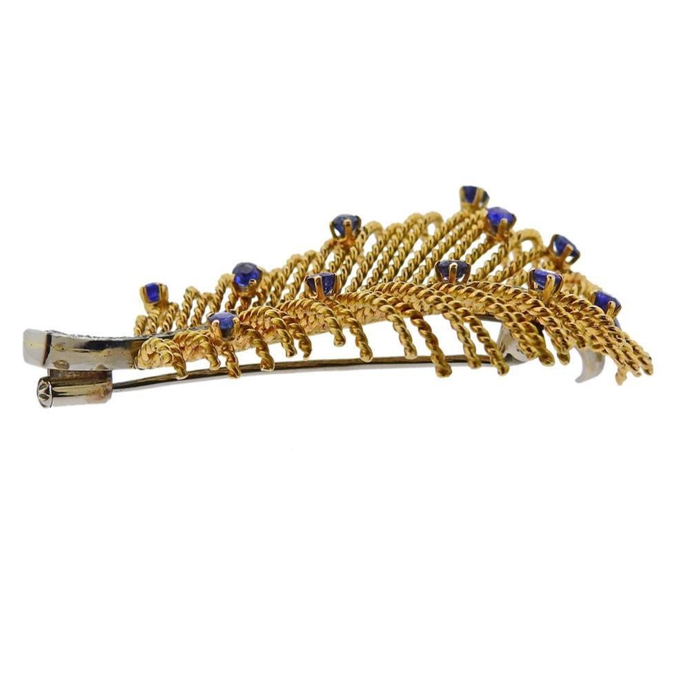 18k yellow gold feather brooch,set with blue sapphires and approx. 0.14ctw in diamonds. Brooch measures 56mm x 32mm. Marked: 750 and gold stamp. Weight - 12.8 grams.