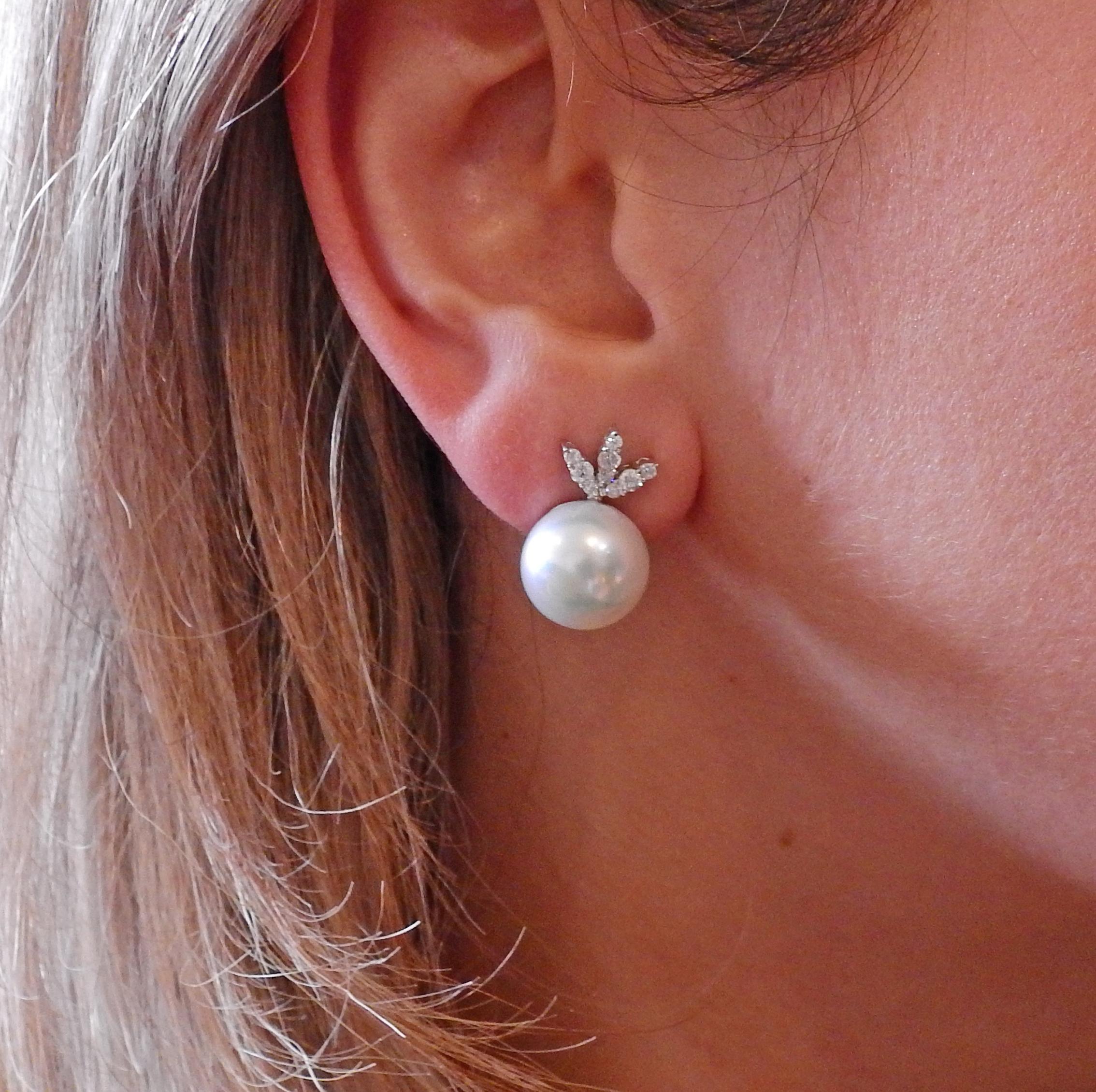 Pair of classic 18k white gold earrings, featuring 13.7mm South Sea pearls, accented by approx. 0.48ctw in SI1-SI2/H diamonds.  Earrings measure 22mm x 14mm. Weight is 12.9 grams. Marked: 18k Maker's mark.