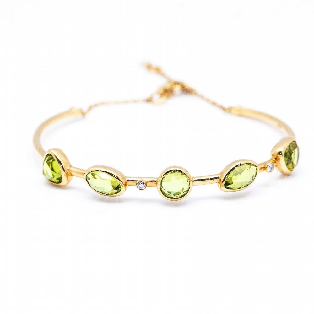 Rigid bracelet in Yellow Gold, Diamonds and 5x Peridots for women  Peridots interspersed with Diamond in Brilliant cut  18 kt Yellow Gold.  10.80 grams  Carabiner closure, fits two sizes  Measurements: Width 6cm  Brand new product  RefD362068SO