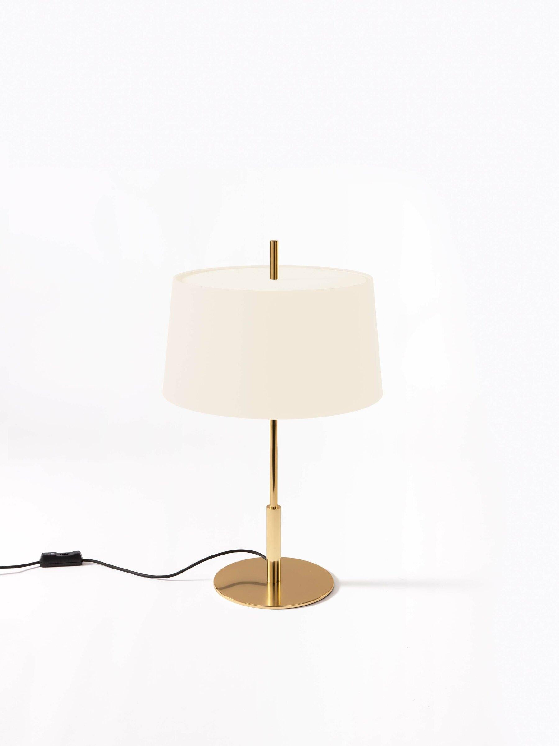 Gold Diana menor table lamp by Federico Correa, Alfonso Milá, Miguel Milá
Dimensions: D 40 x H 66 cm
Materials: White linen, metal.
Available in black or white lampshade and in gold or nickel finish.

In keeping with the calling of its