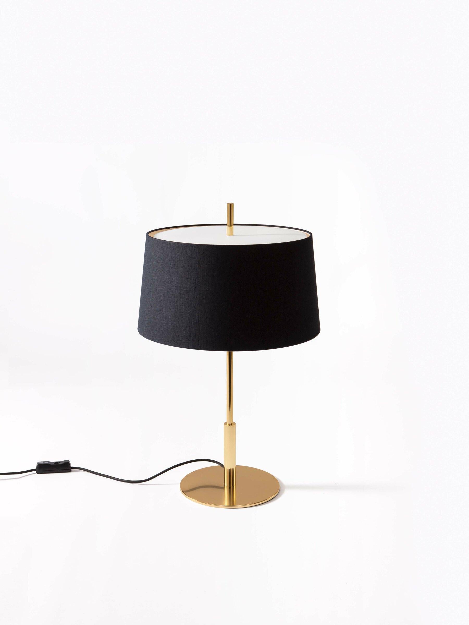 Gold Diana menor table lamp by Federico Correa, Alfonso Milá, Miguel Milá
Dimensions: D 40 x H 66 cm
Materials: Black linen, metal.
Available in black or white lampshade and in gold or nickel finish.

In keeping with the calling of its