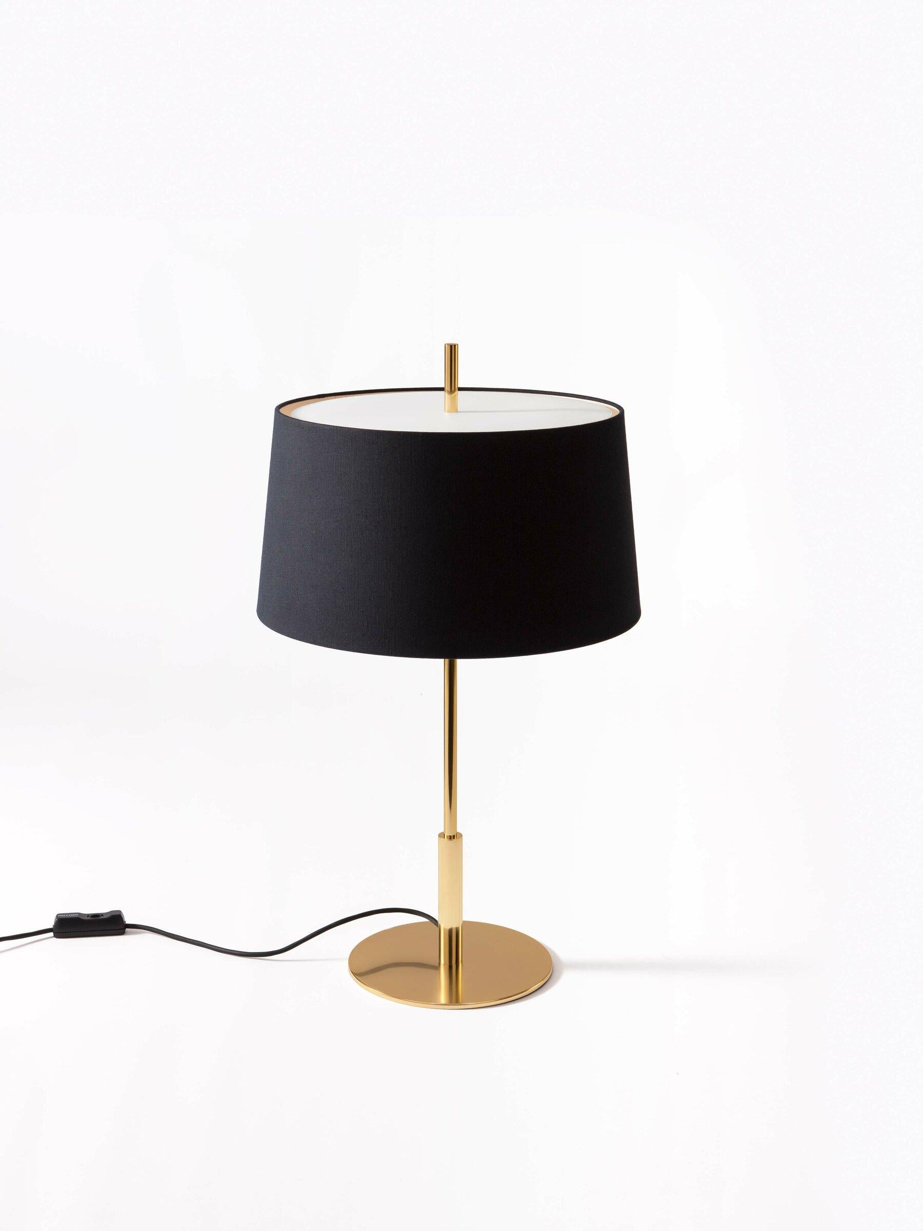 Gold Diana table lamp by Federico Correa, Alfonso Milá, Miguel Milá
Dimensions: D 45 x H 78 cm
Materials: black linen, metal.
Available in black or white lampshade and in gold or nickel finish.

In keeping with the calling of its creators, the
