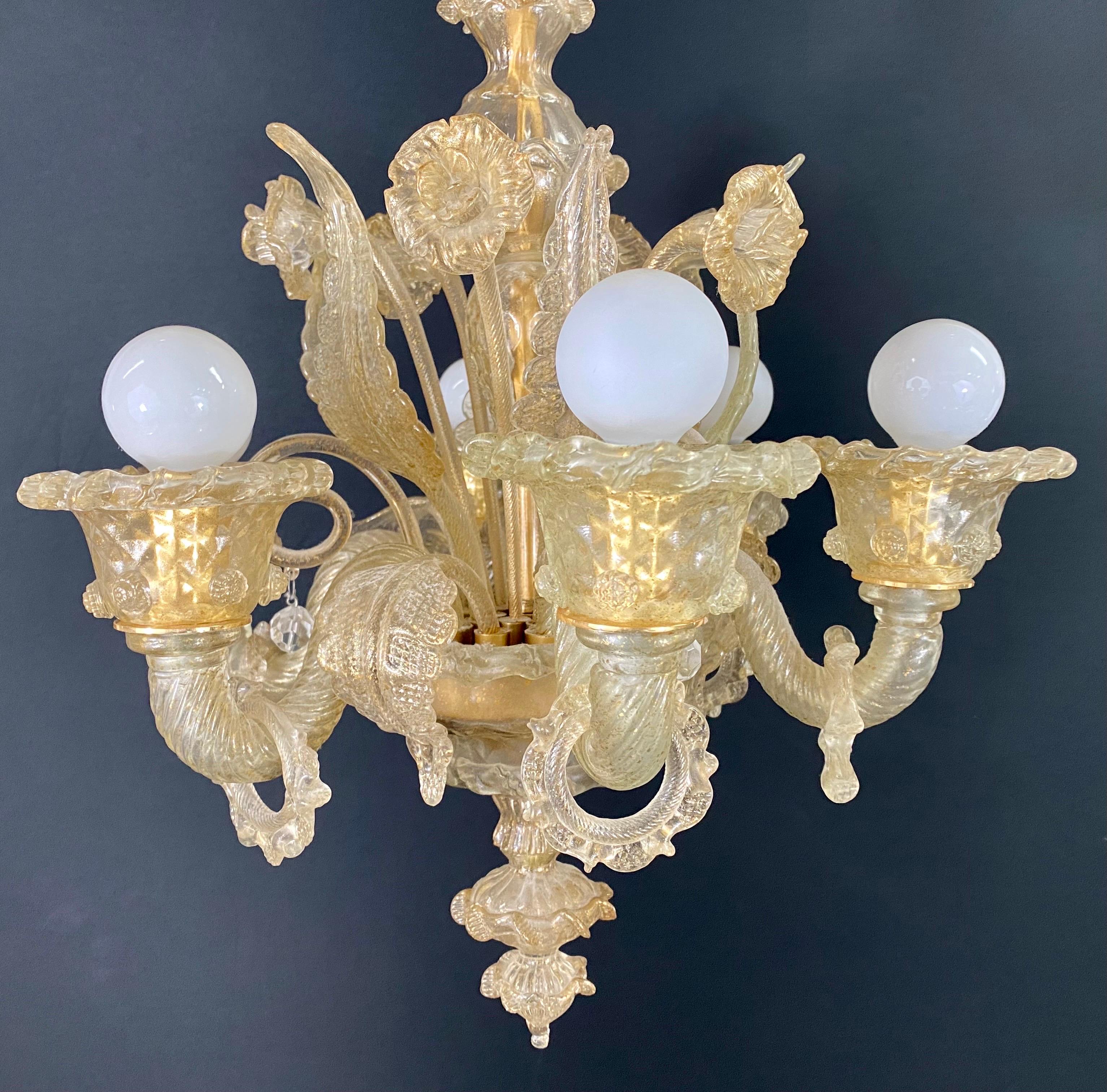 A stunning vintage 1950's all Murano glass chandelier attributed to Compagnia Di Venezia E Murano. The beautiful chandelier is made of quality Murano glass having gold dust making the chandelier look more opulent and elegant. The chandelier is