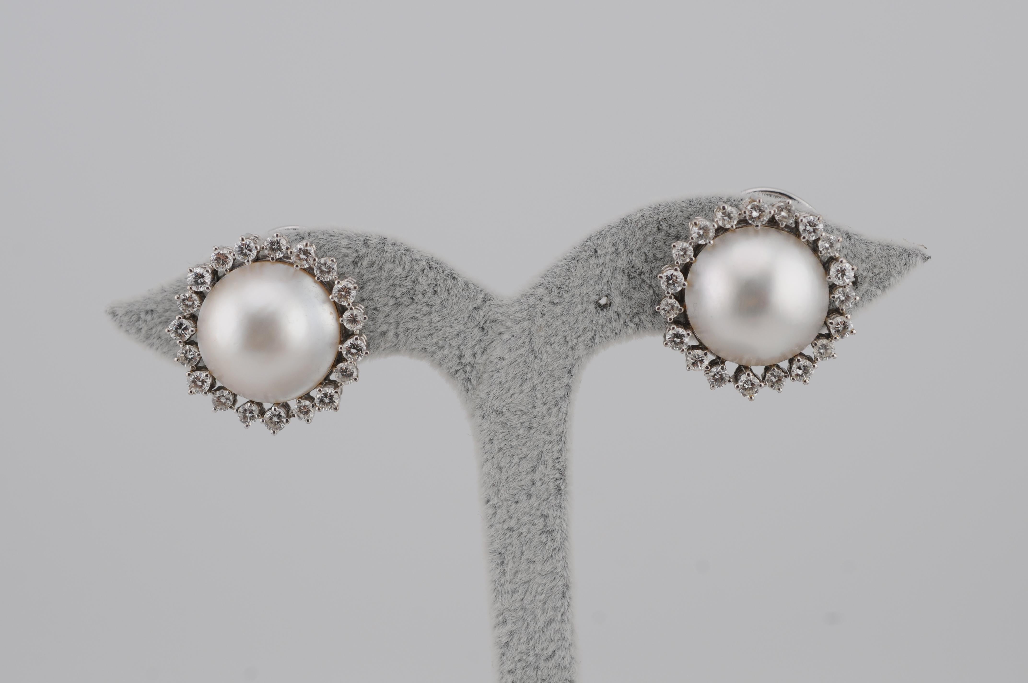 Raffinati orecchini in oro bianco 18 carati con perle Akoya a forma di mezzo giro e 42 diamanti a taglio brillante di circa 0,03 carati ciascuno, per un peso totale di circa 1,26 carati. La coppia ha un peso complessivo di 16,30 g e misura 21 x 21