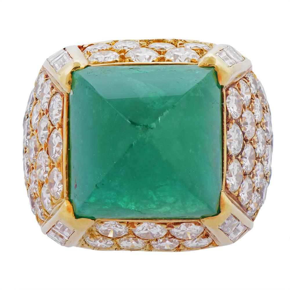 A gold, emerald and diamond ring by O.J. Perrin, French, centring on a pyramid-shaped cabochon emerald mounted in a four-sided surround pavé-set with round-cut diamonds, the edges set with baguette-cut diamonds. Signed O.J.P PARIS and bearing French