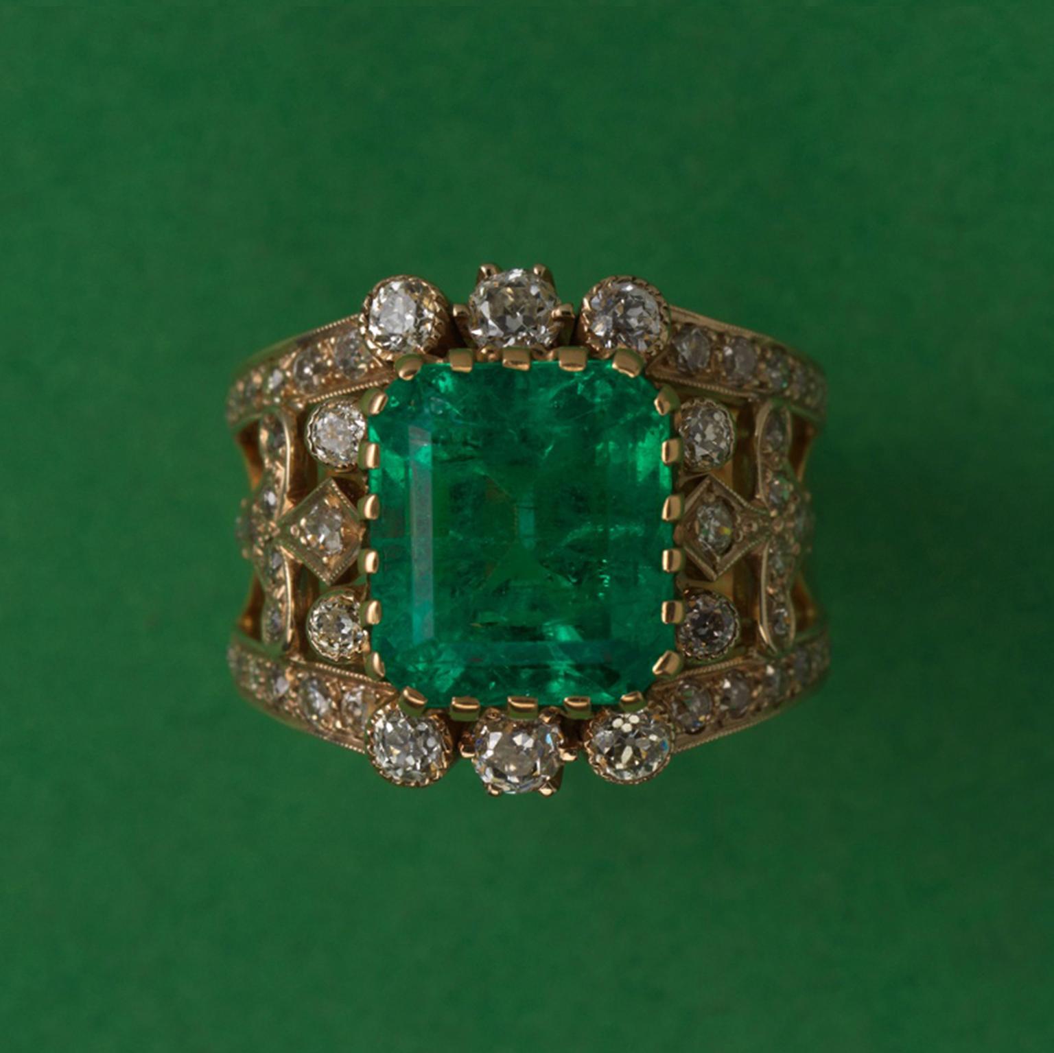 An 18 carat gold ring with a large emerald cut Colombian emerald (8.5 carats) around which are 48 old cut diamonds (1.5 carat).

ring size: 17.75 mm 7 ½ US
weight: 14.07 gram.